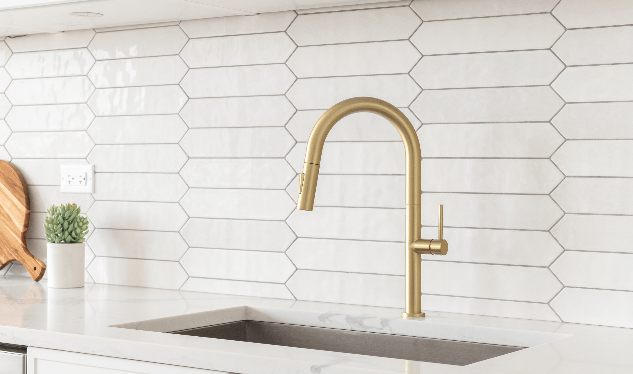 A pristine kitchen with a large, geometric backsplash.