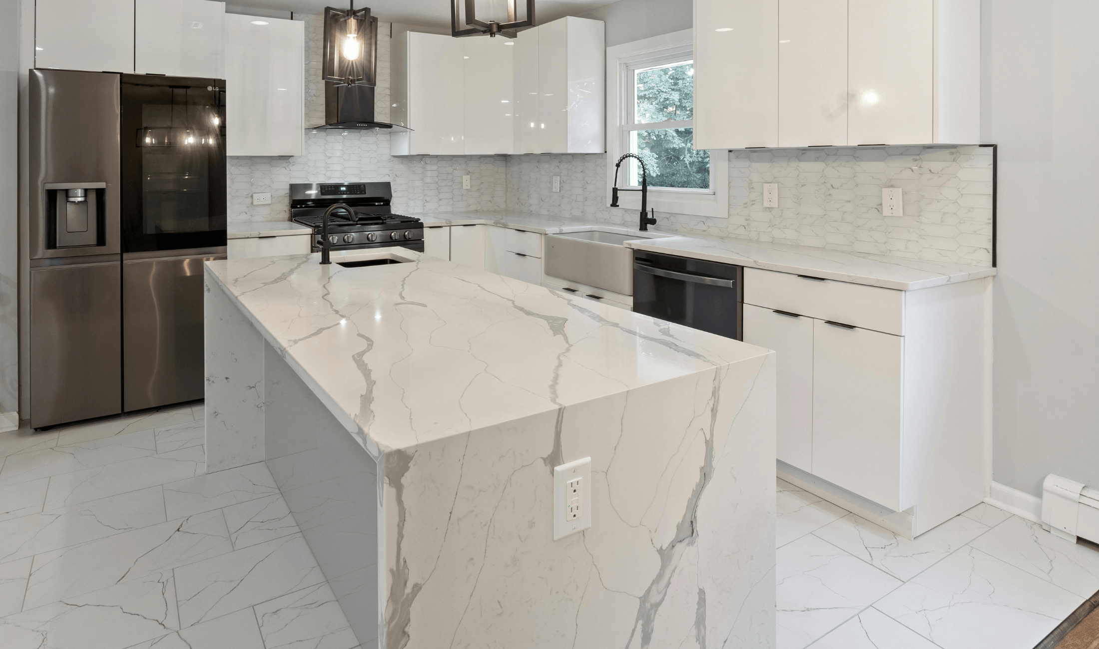A bright white kitchen with marble countertops.