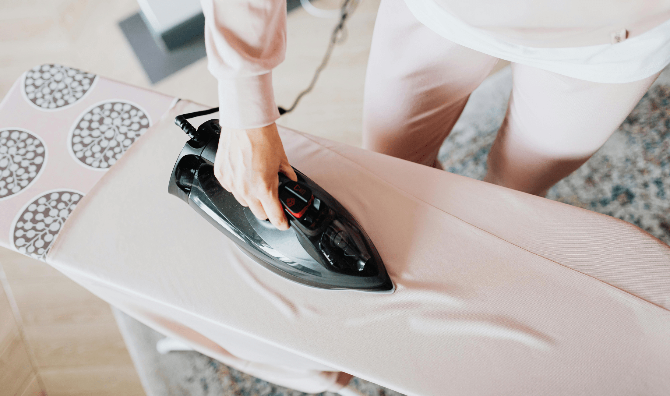 Someone ironing a shirt on an ironing board.