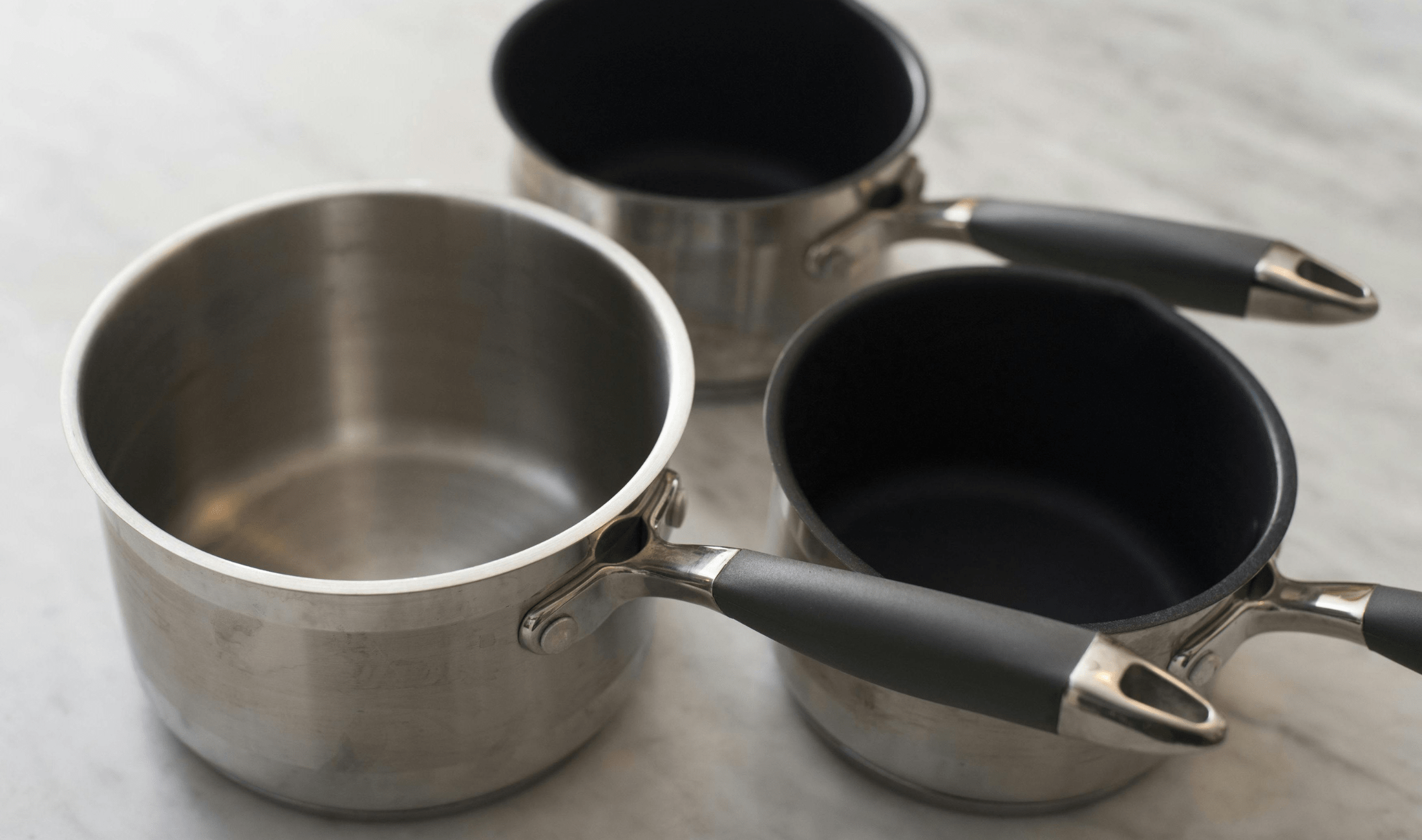 A collection of 3 aluminum pots.