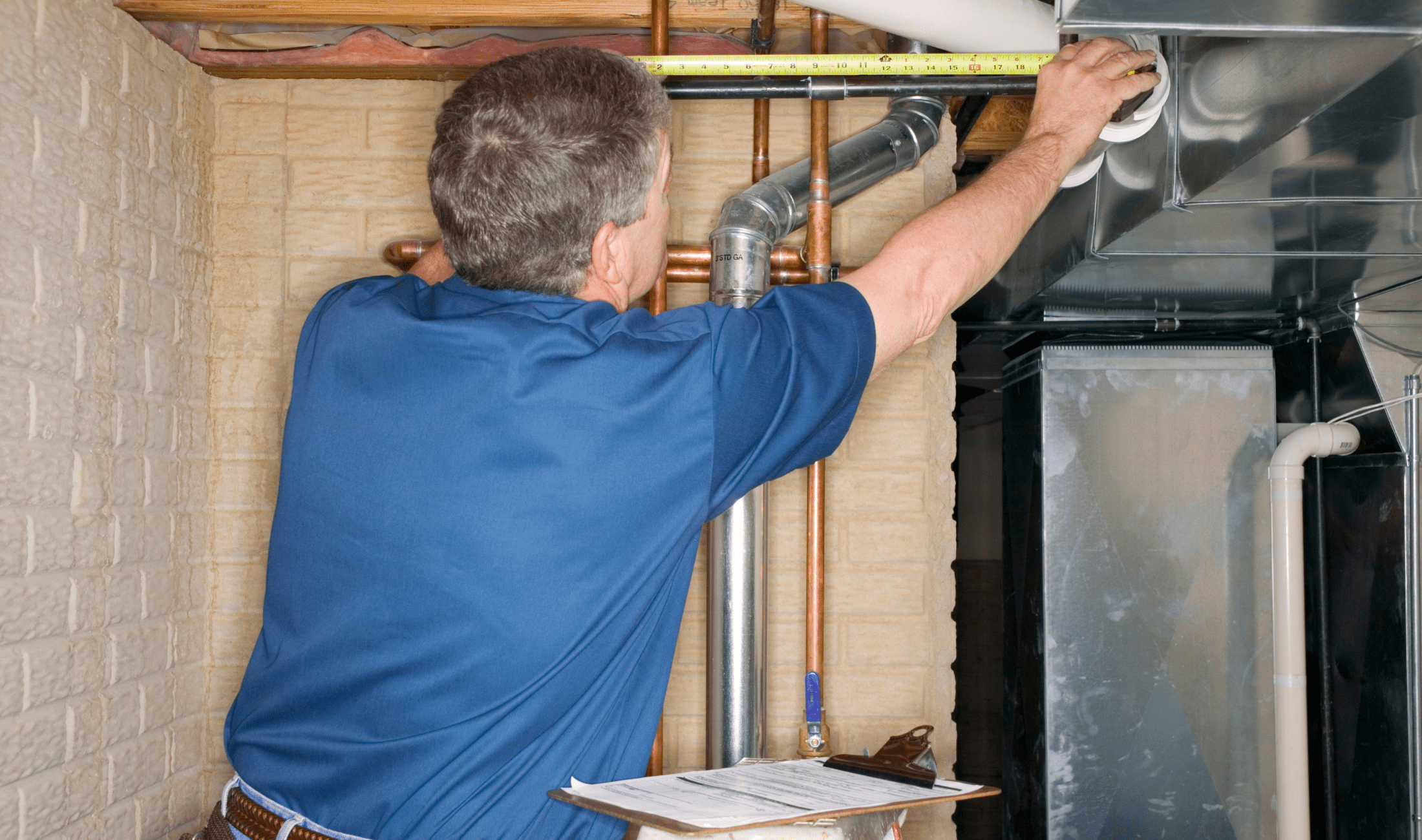 A plumber doing an inspection on a water heater.
