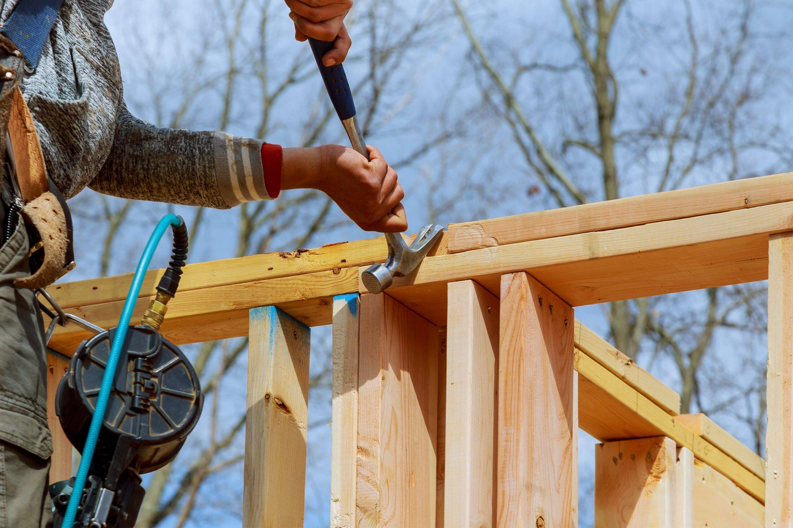 Authentic construction worker framing building contractor using nail gun