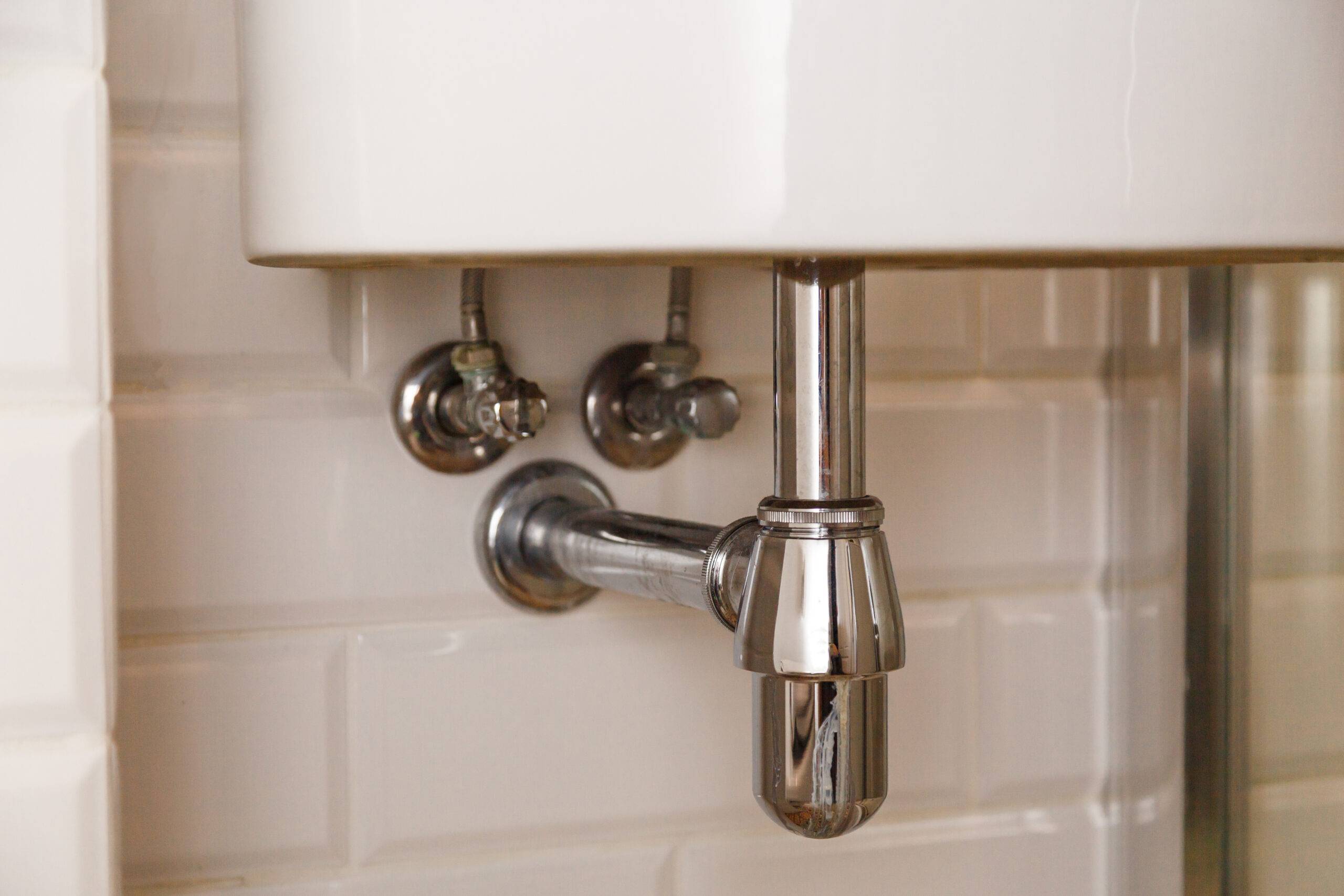 Basin siphon or sink drain in a bathroom, clean.