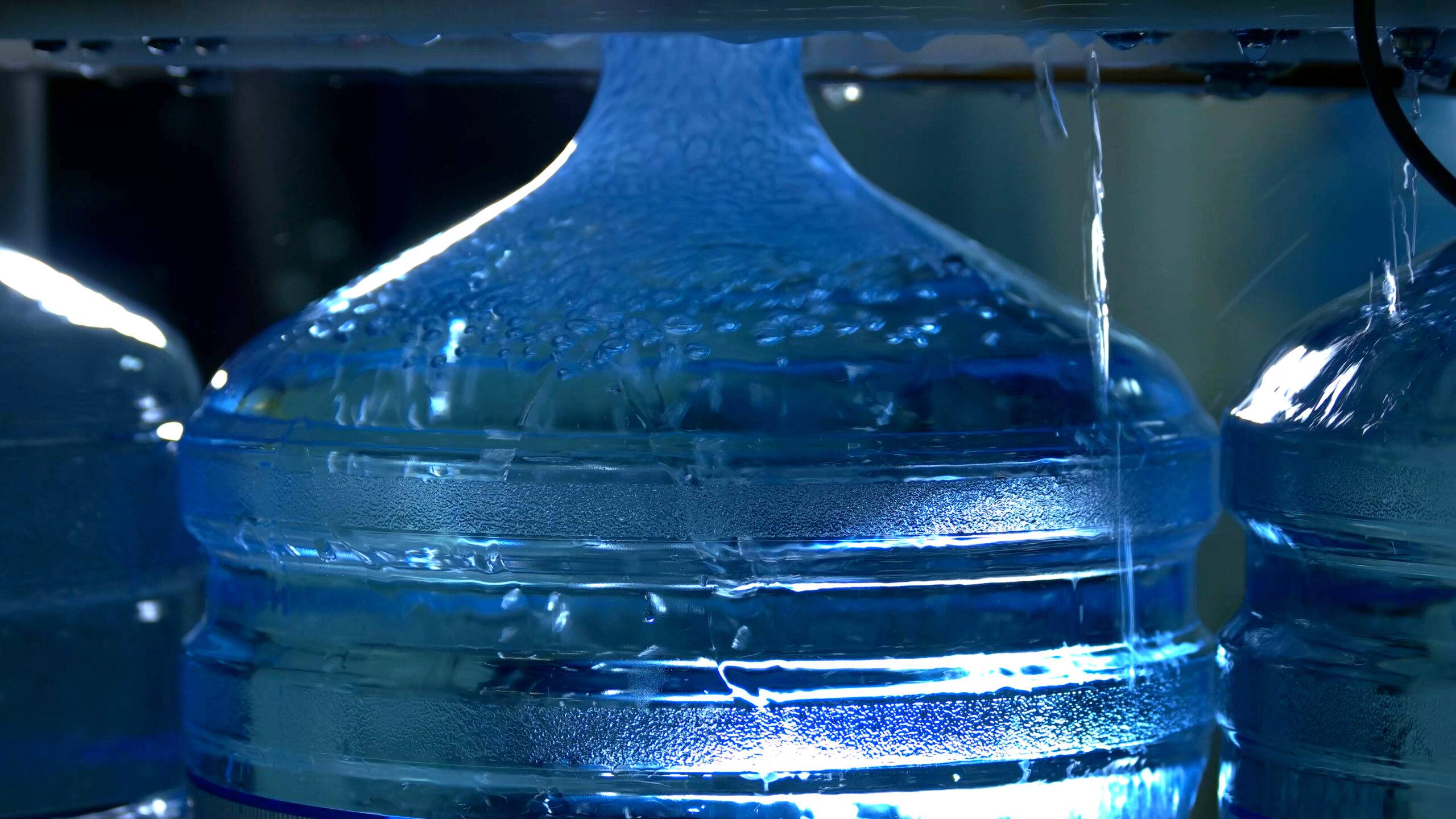 Bottle being filled with water. Ultra clean bottled water production line. Manufacture gallon filling machine.