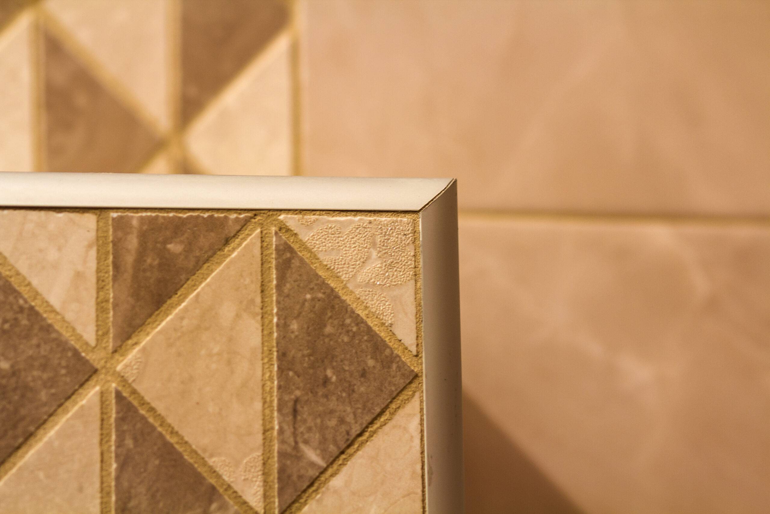 Close-up of ceramic tiles out corner with silver metal strip on the interior wall