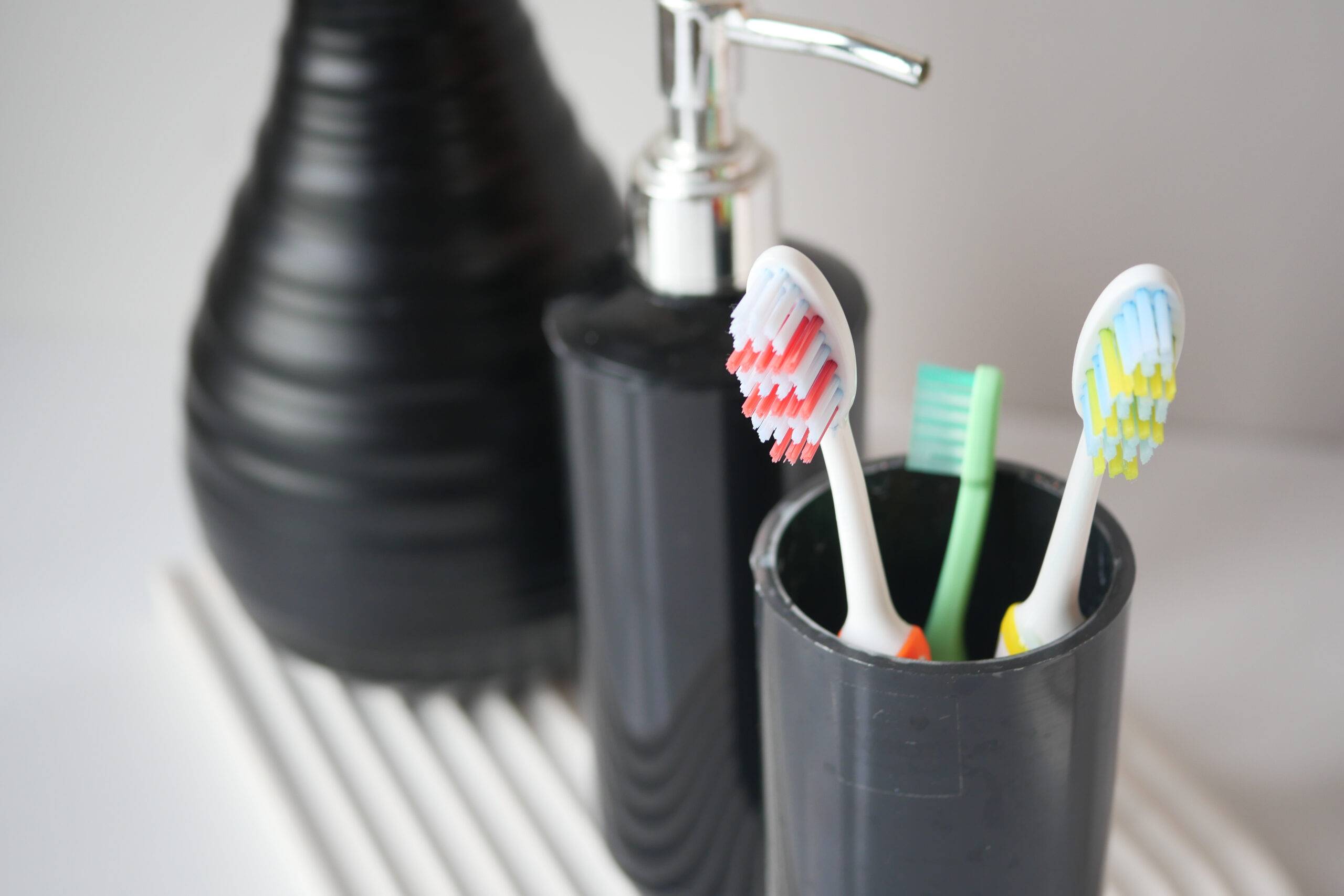 colorful toothbrushes in black cup.