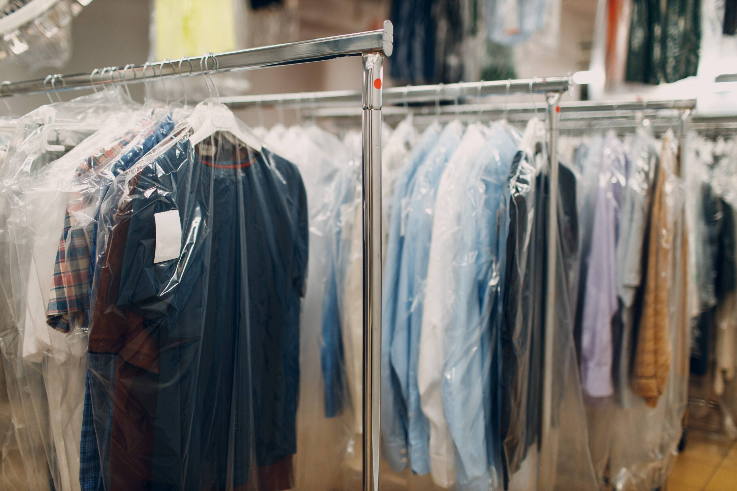 Dry cleaning clothes. Clean cloth chemical process. Laundry industrial dry-cleaning hanging clothes on rack