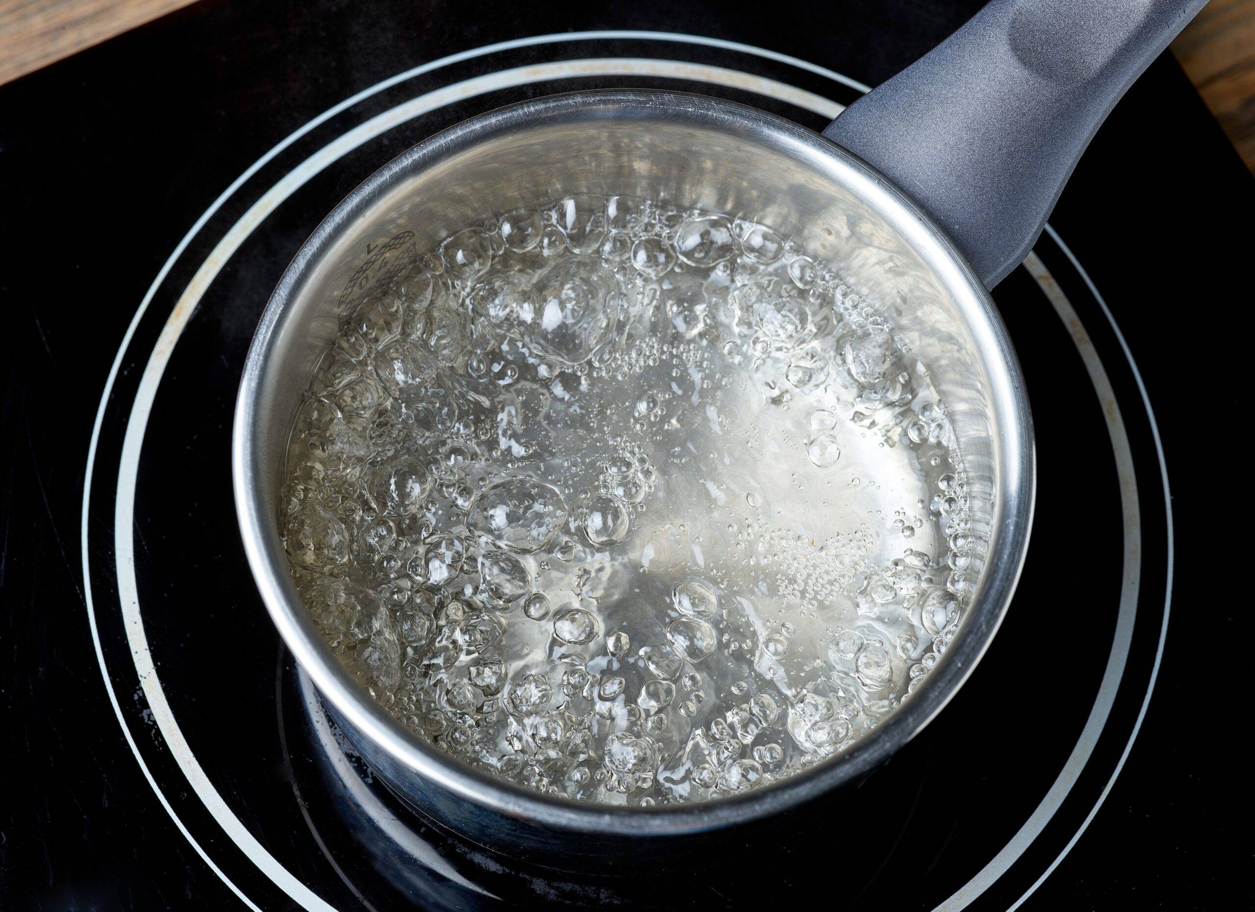 A pot of boiling water on an electric stove.