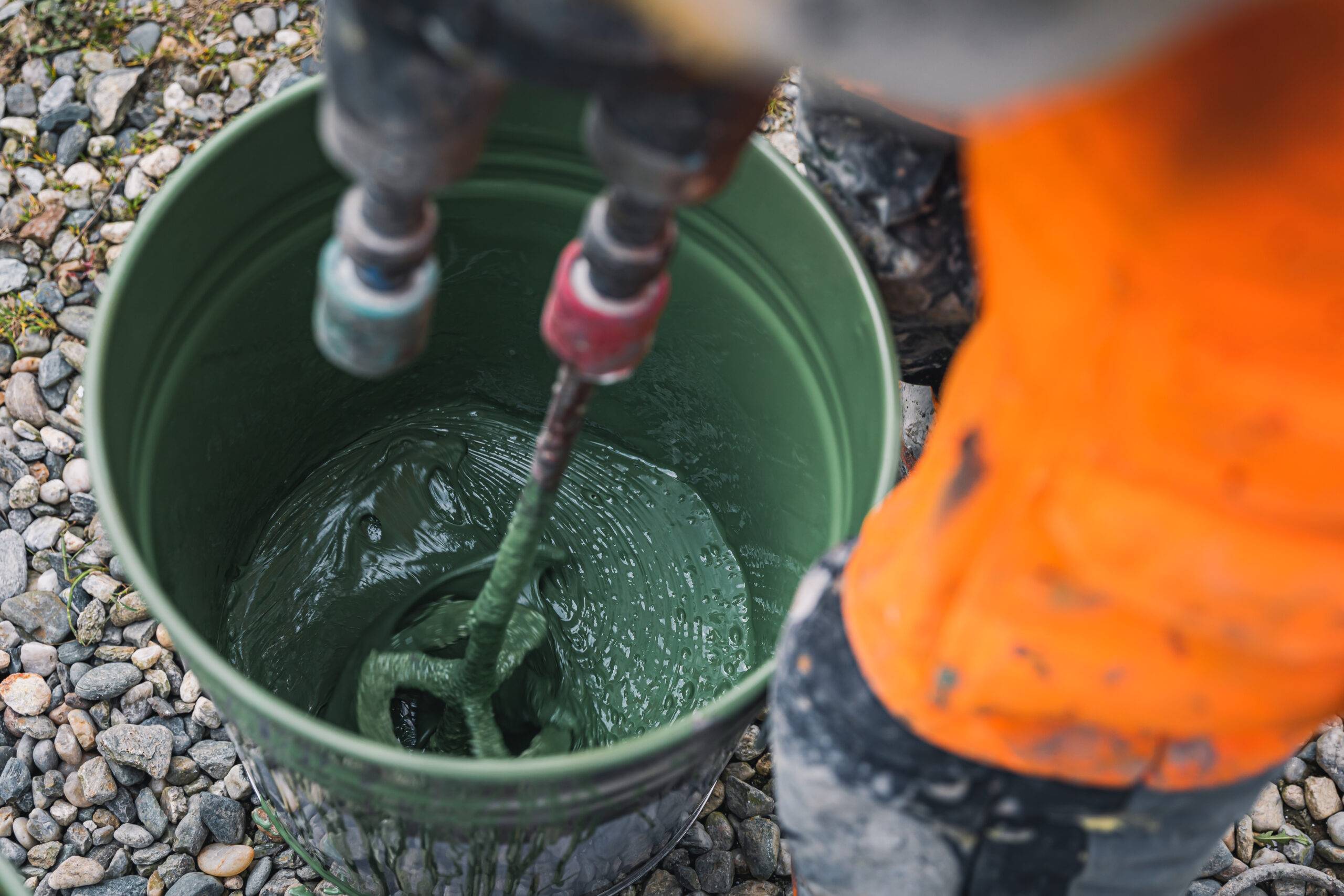 Skilled worker mixes epoxy resin paint. Epoxy flooring tools, preparation and application of epoxy resin