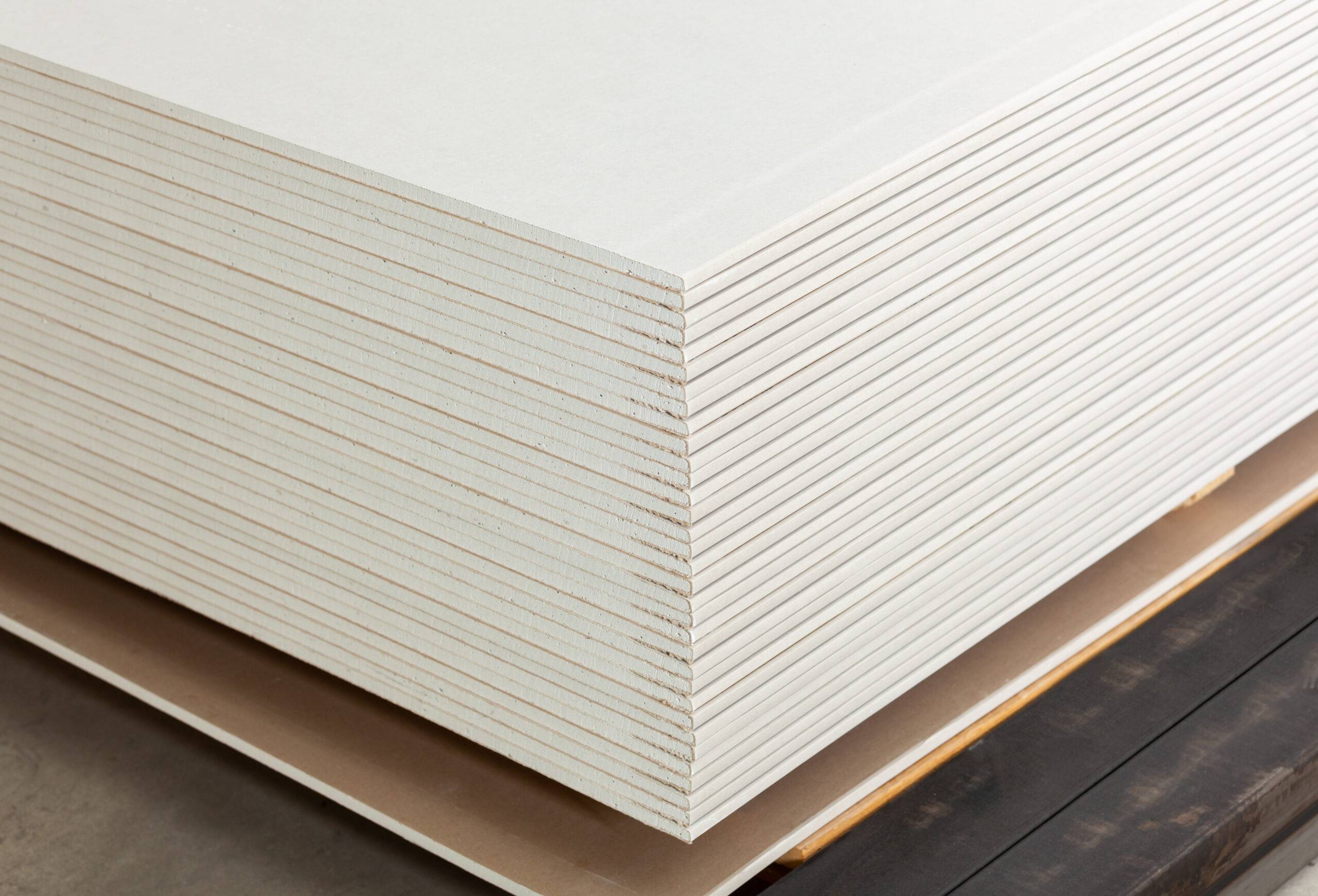 Stacking of white gypsum panels, drywall or plasterboard.