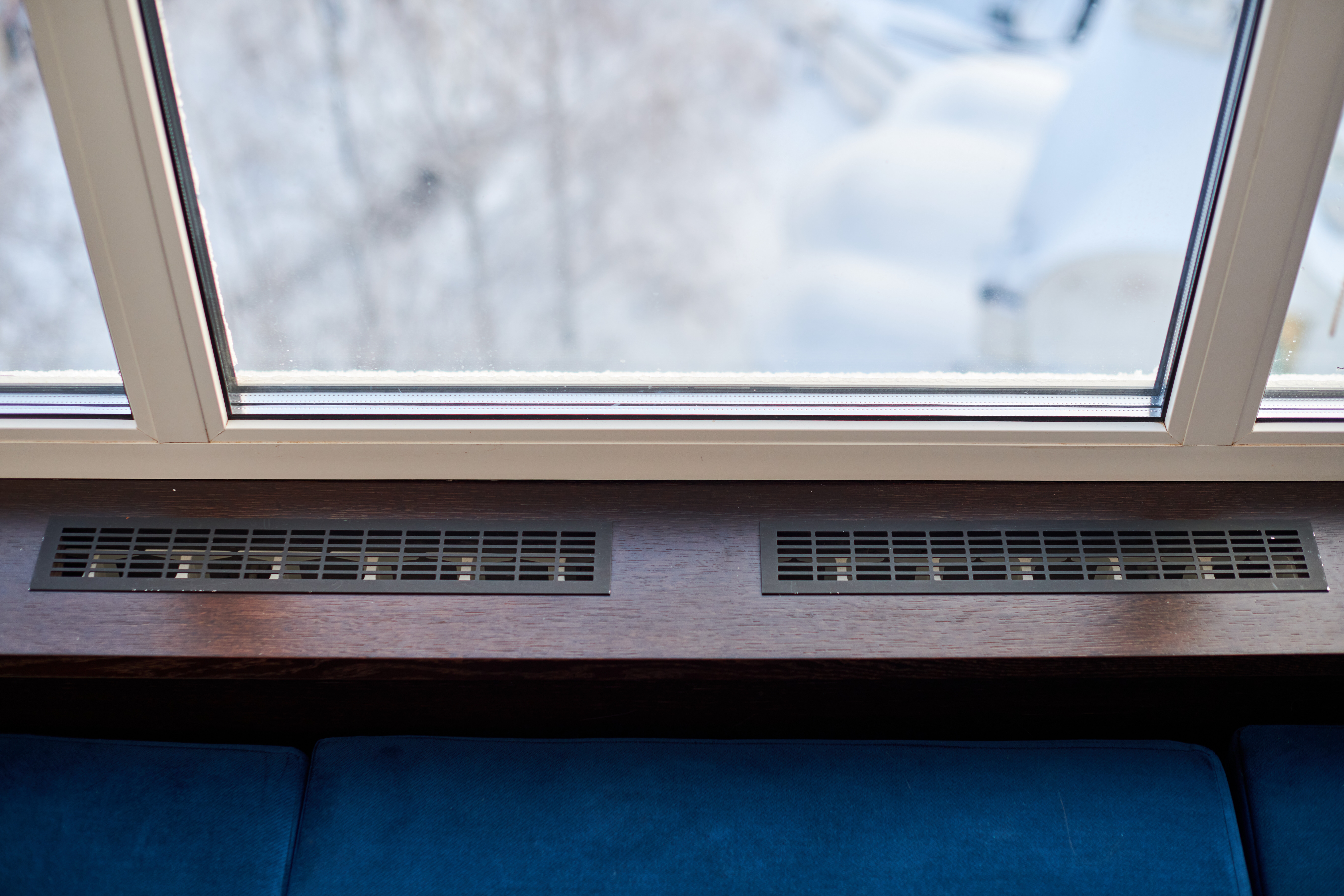 Windowsill, heating grid ventilation. Winter apartment heating. Modern double glazed windows