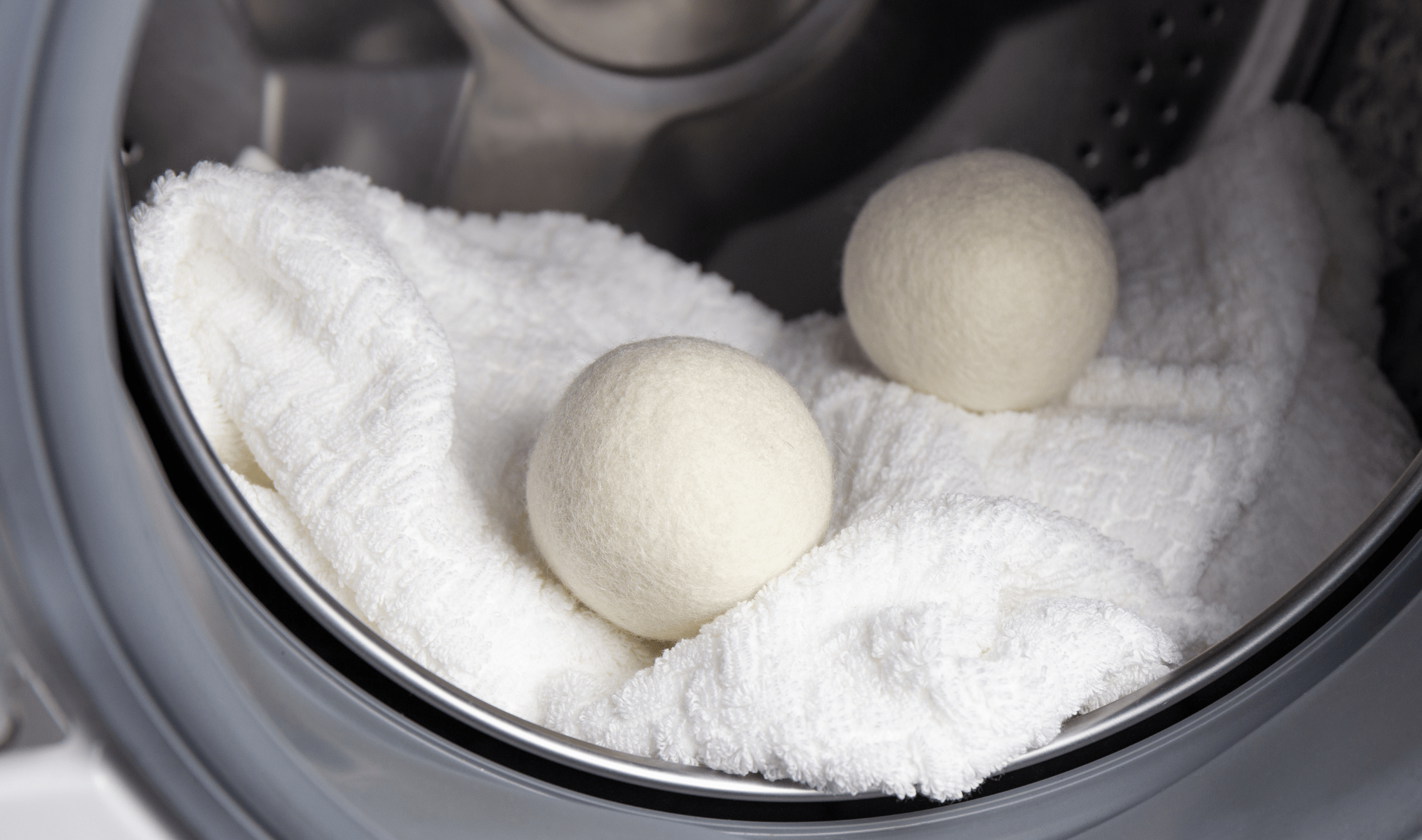 Two dryer balls in a dryer with a blanket.