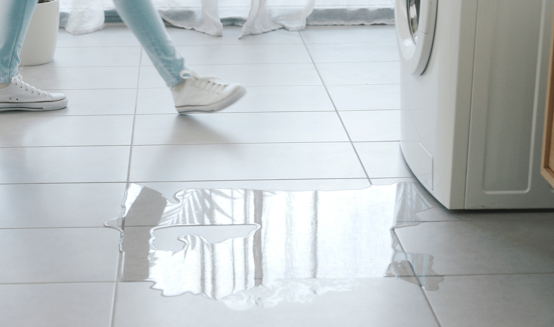 A washing machine leaking water onto the floor.