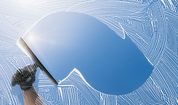 A soapy window being cleaned with a squeegee in the centre.