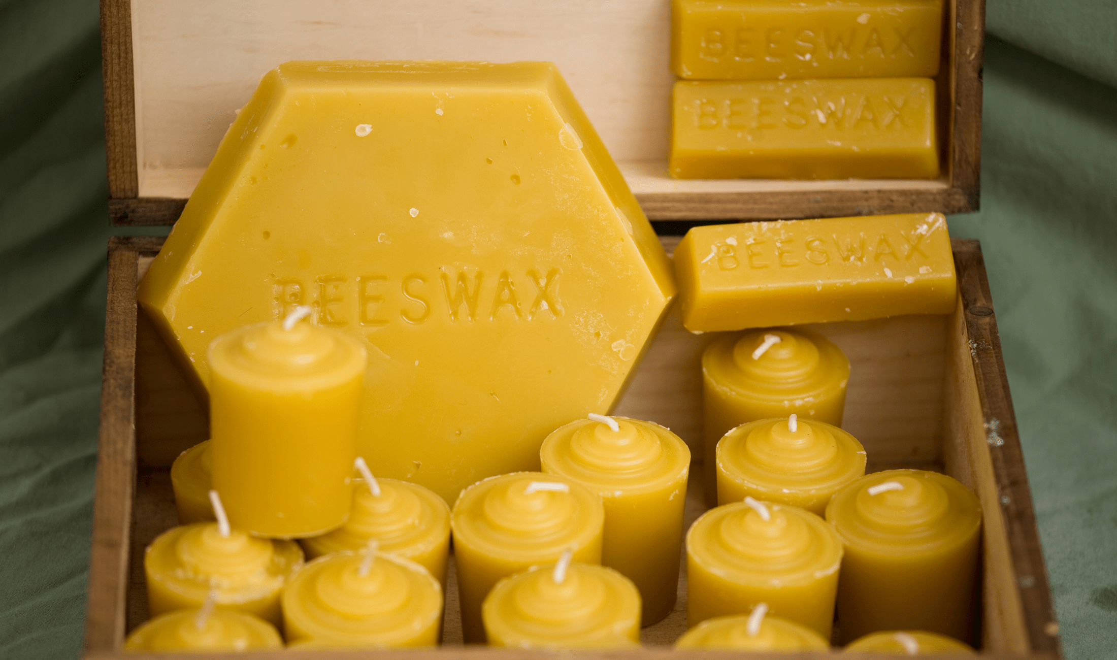 A box full of beeswax bricks and candles.
