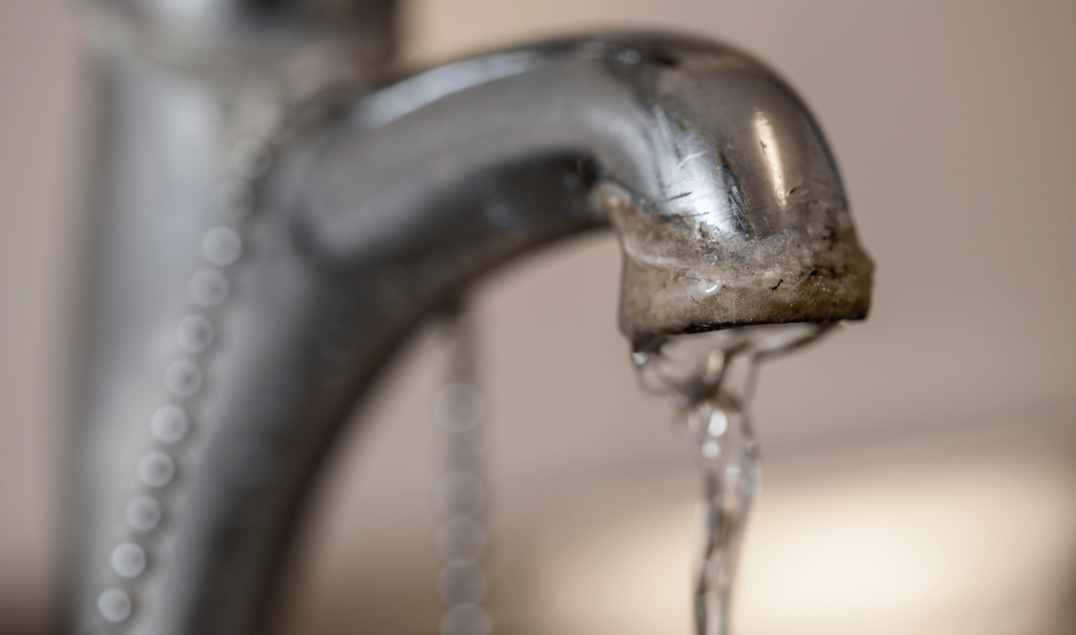 Hard water deposits on a sink faucet.