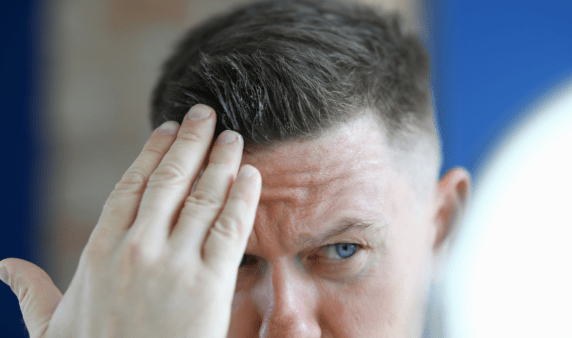 A man putting gel in his hair.