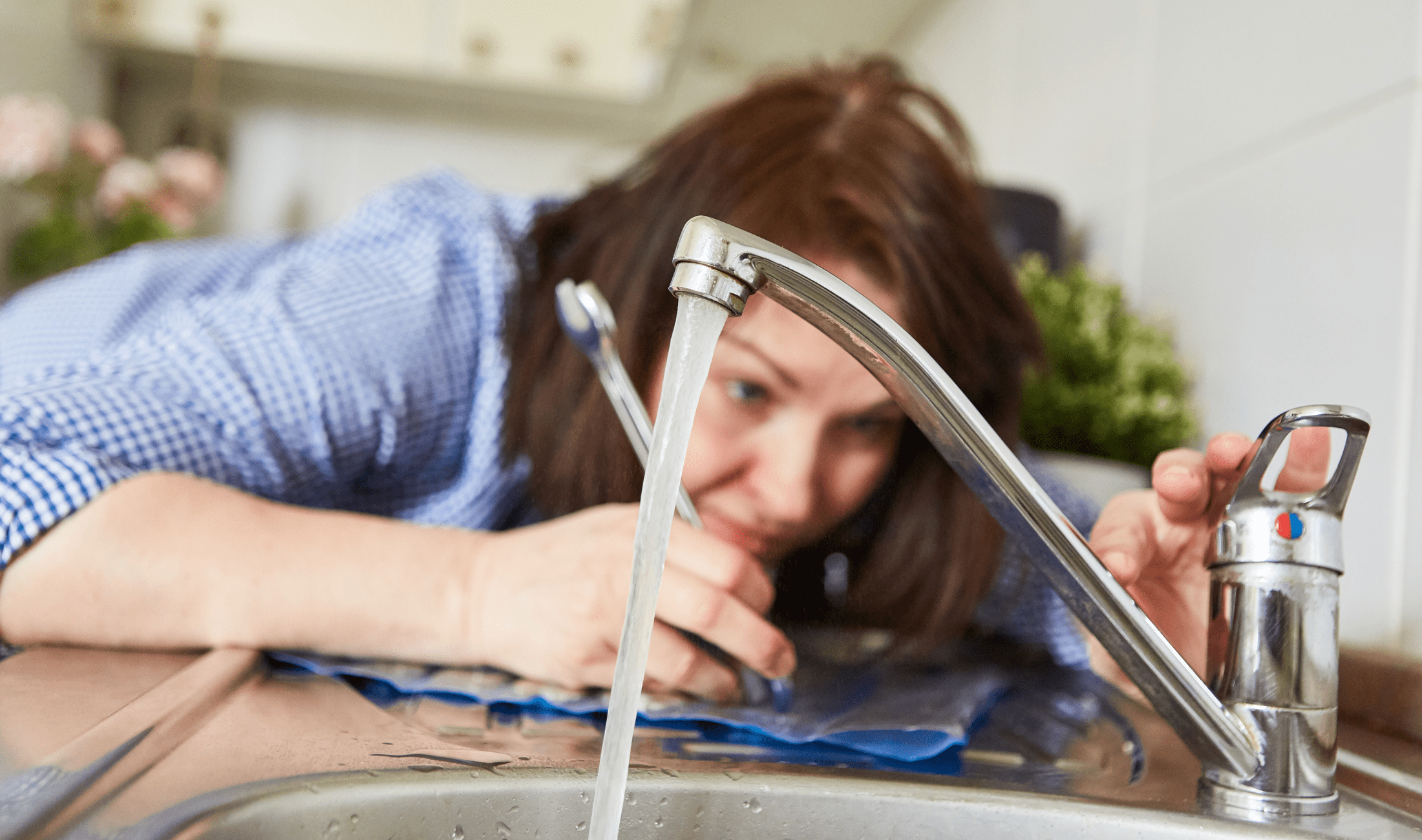 A woman testing a faucet she just installed.