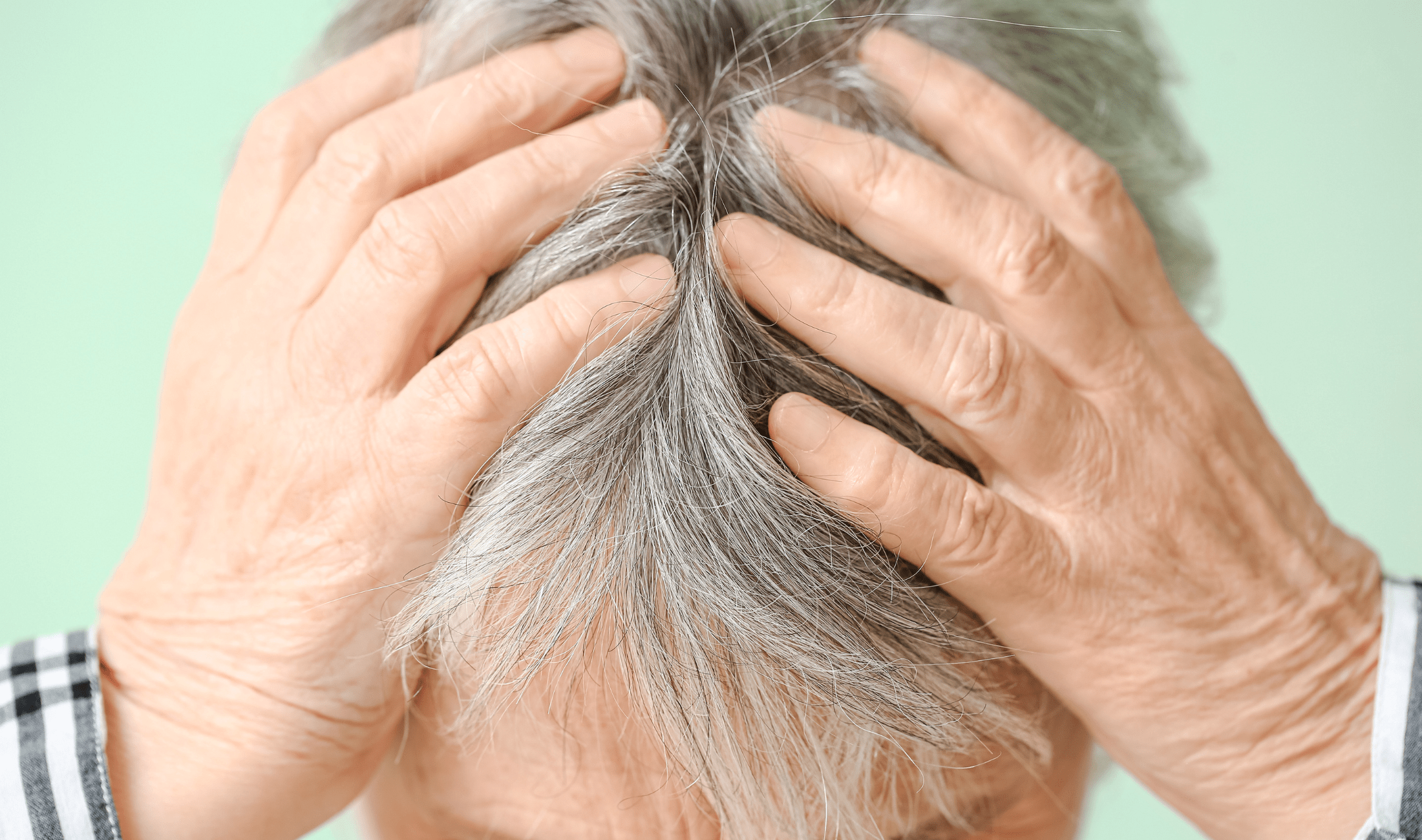 A person with both of their hands in their hair.
