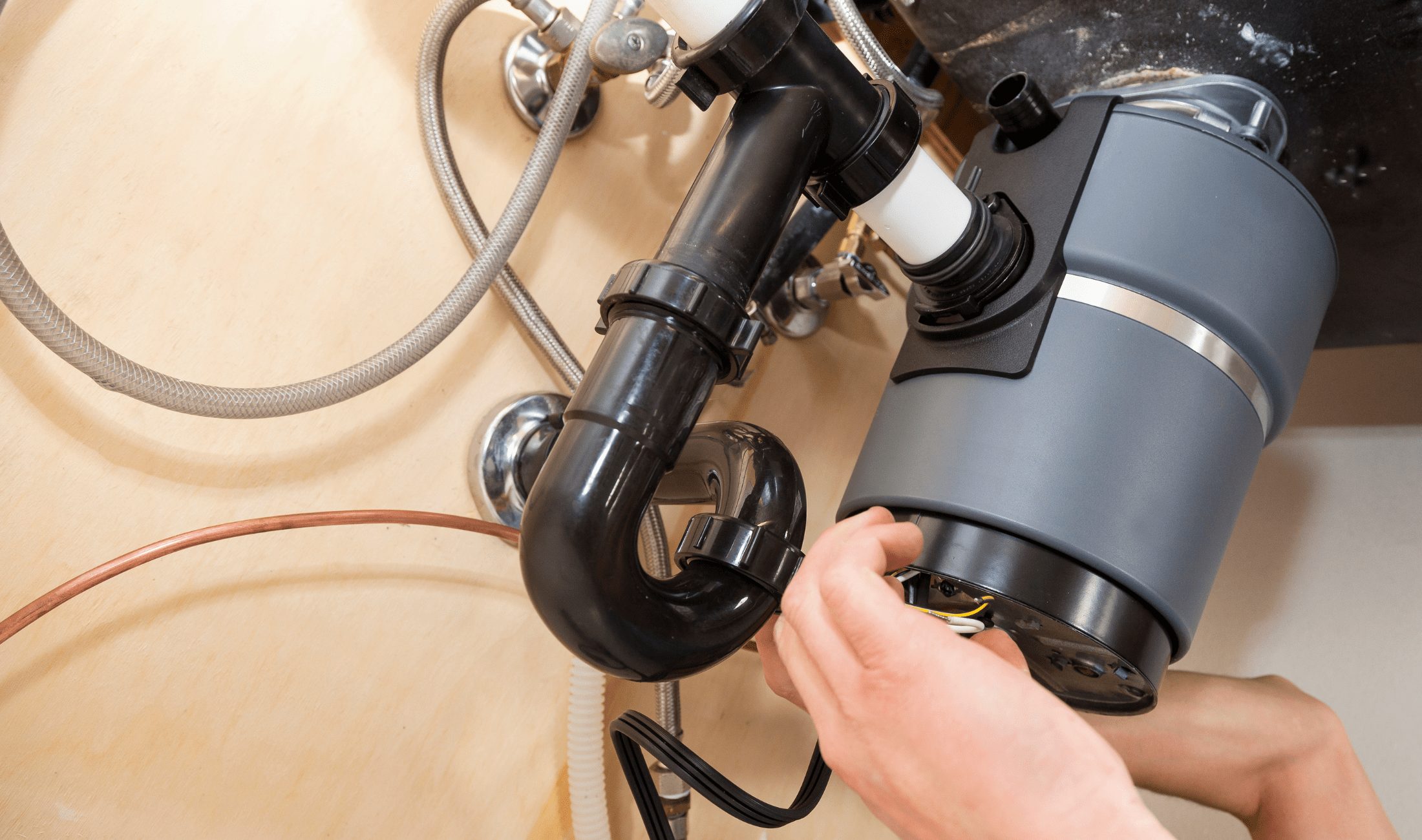 A hand reaching to fix their garbage disposal.