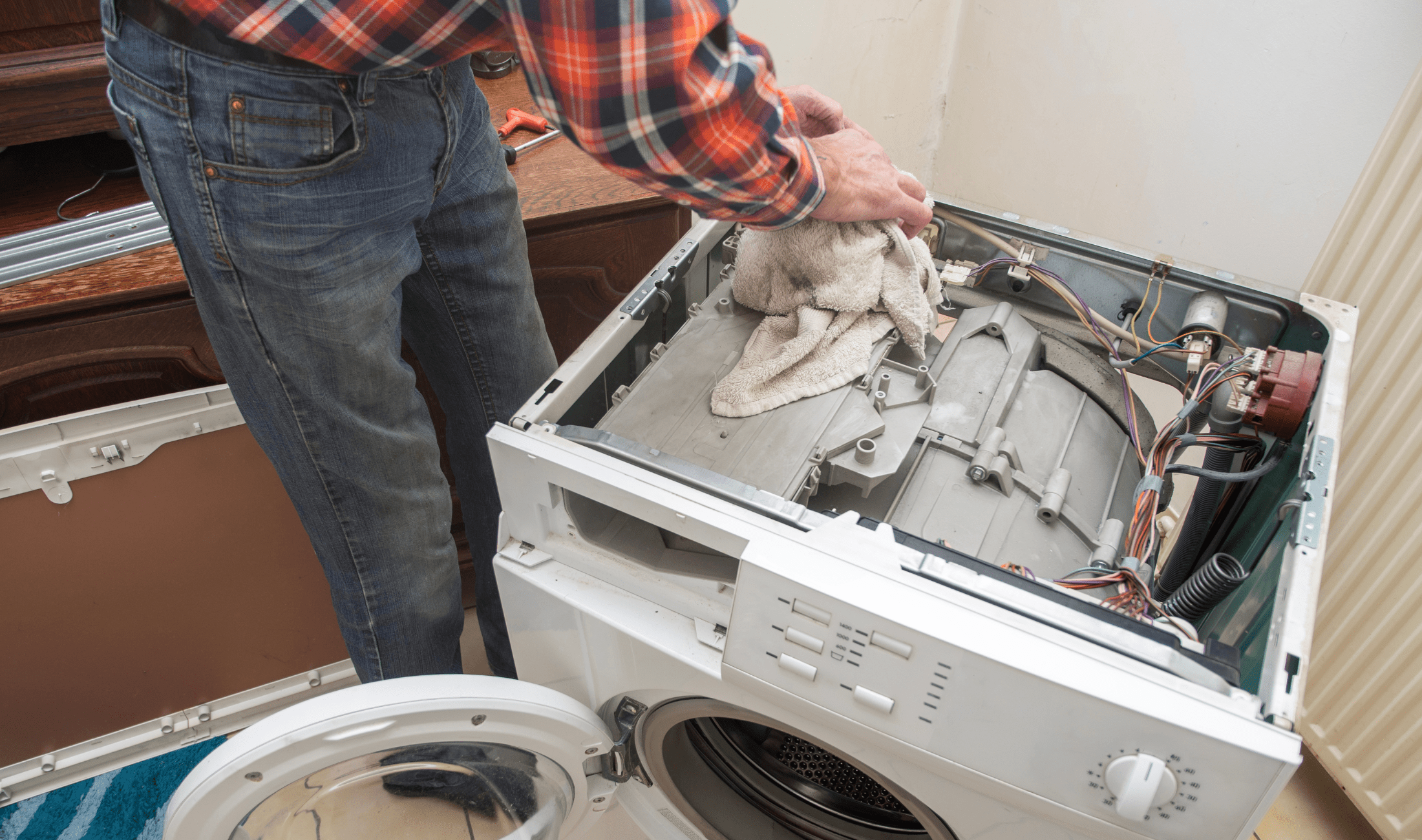 A person repairing a washing machine.