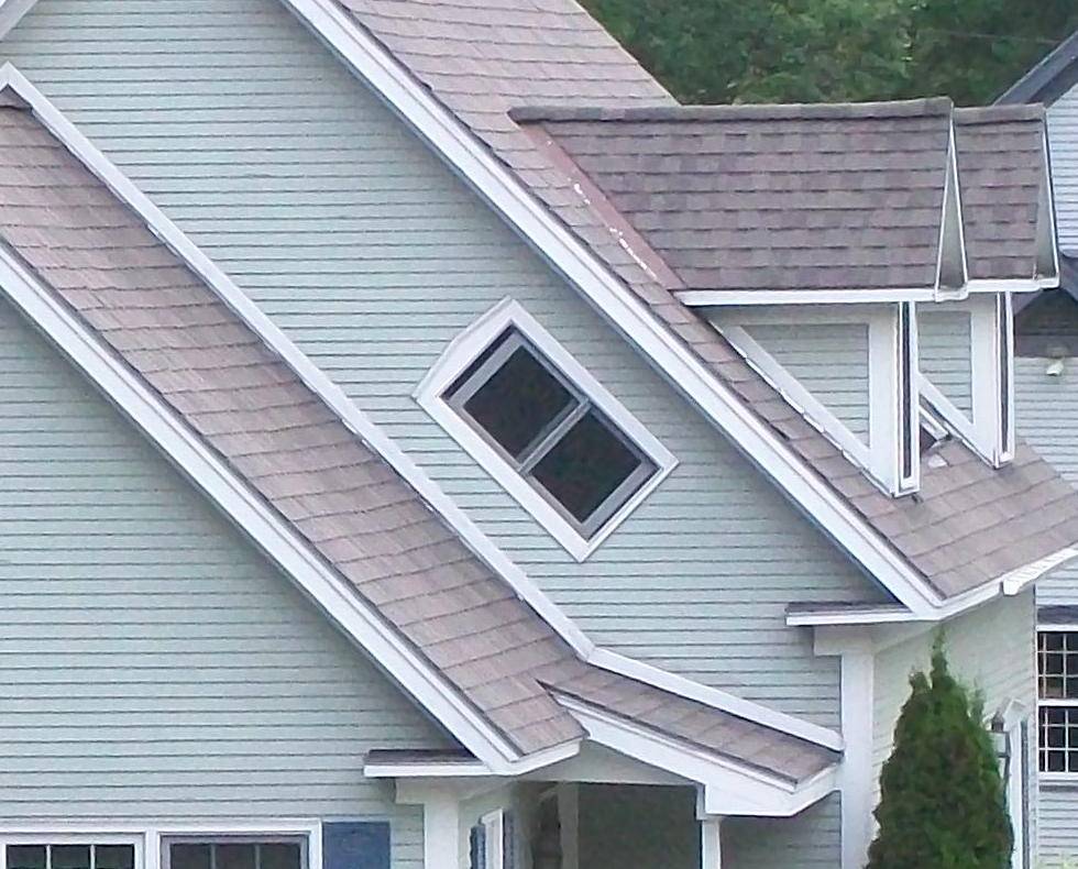 An exterior view of a home with a witch window.