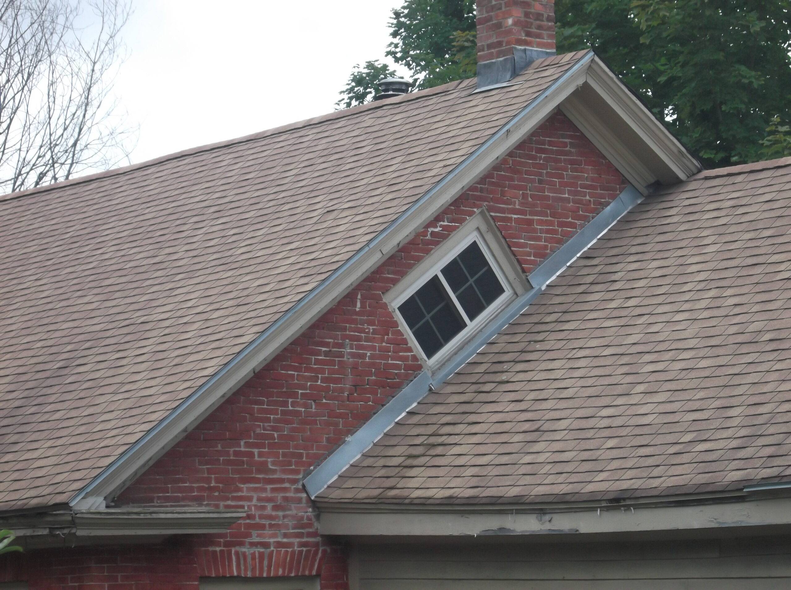 An exterior view of a home with a witch window.
