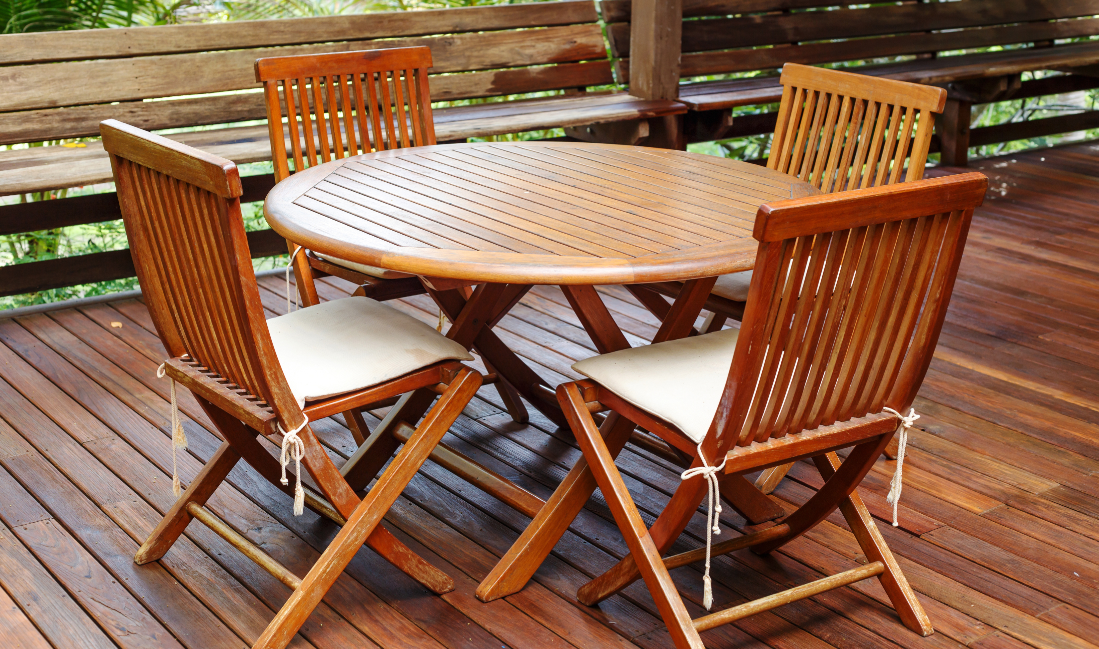 A wooden patio set, slat table with four chairs.