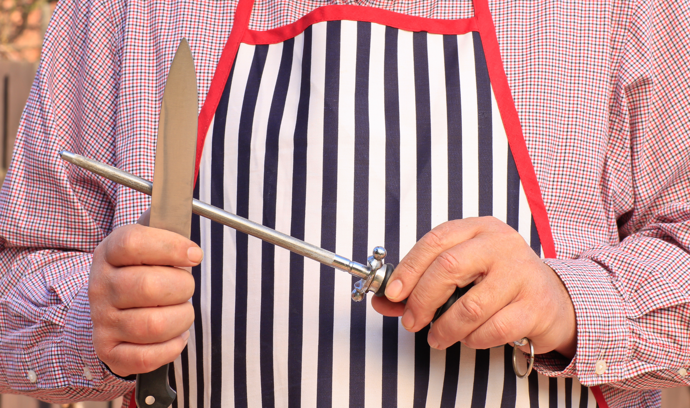 Someone using a honing edge on a knife.