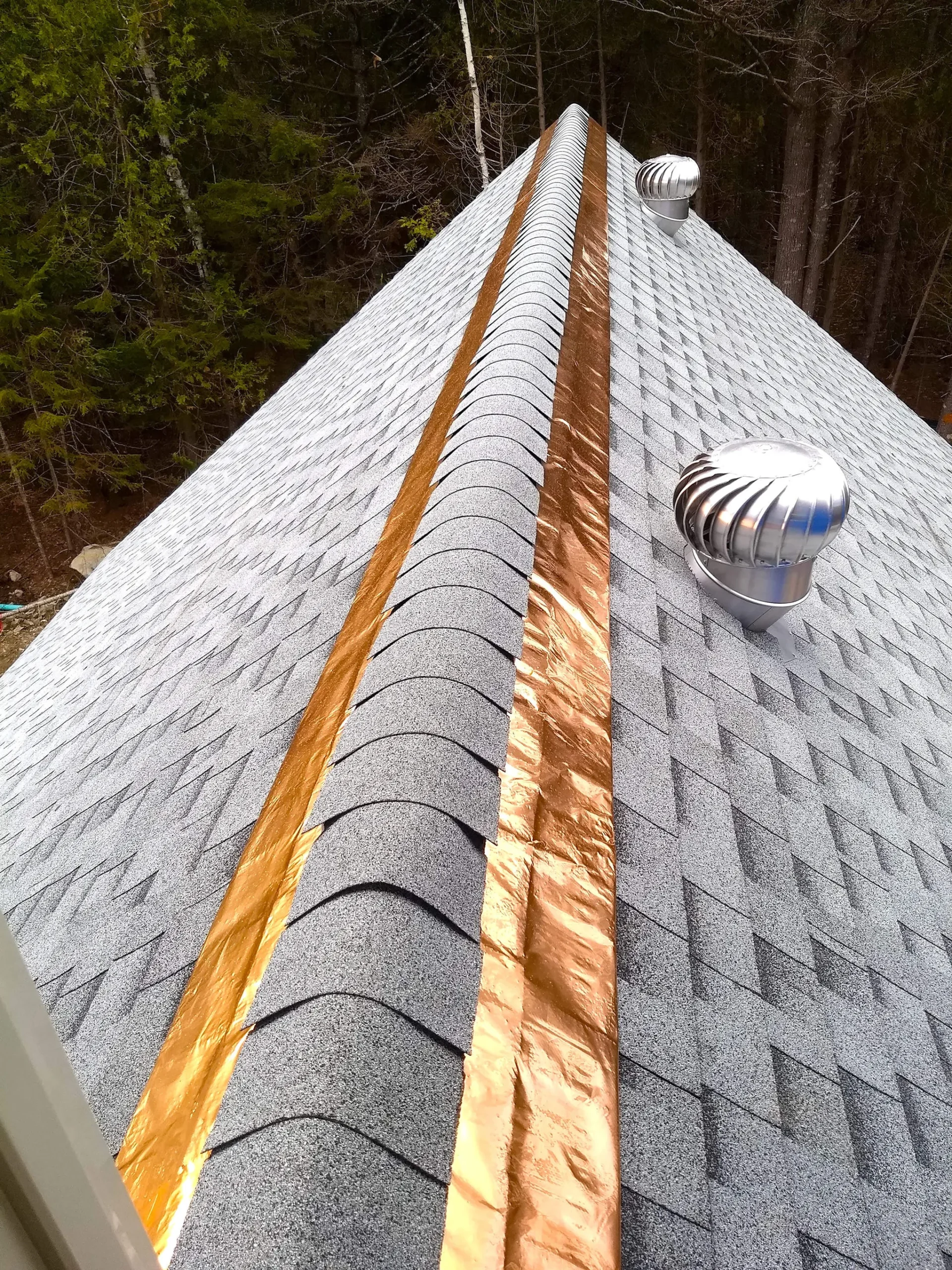 Two strips of copper plating at the very top of a roof.