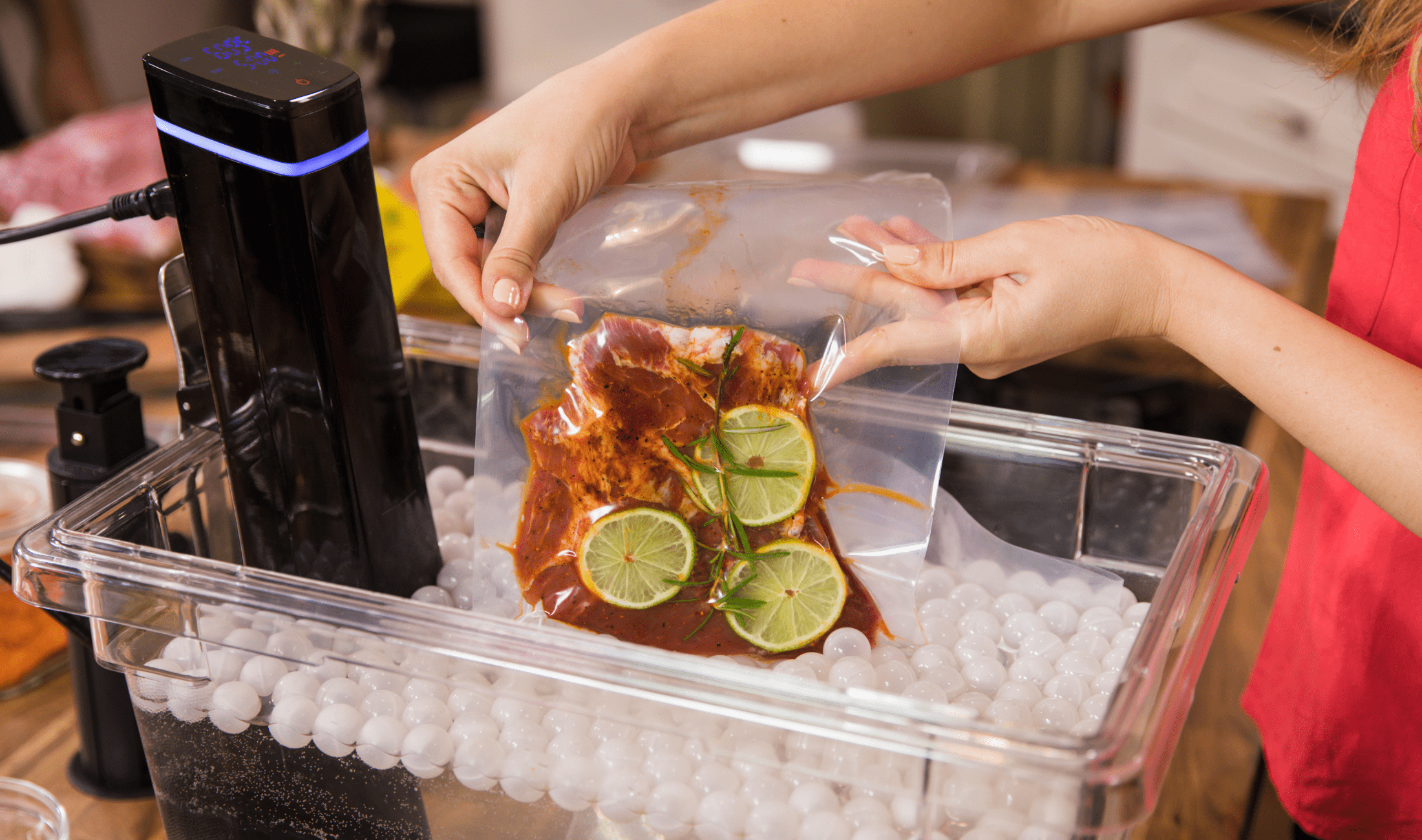 A person putting a steak in a sous vide bath.