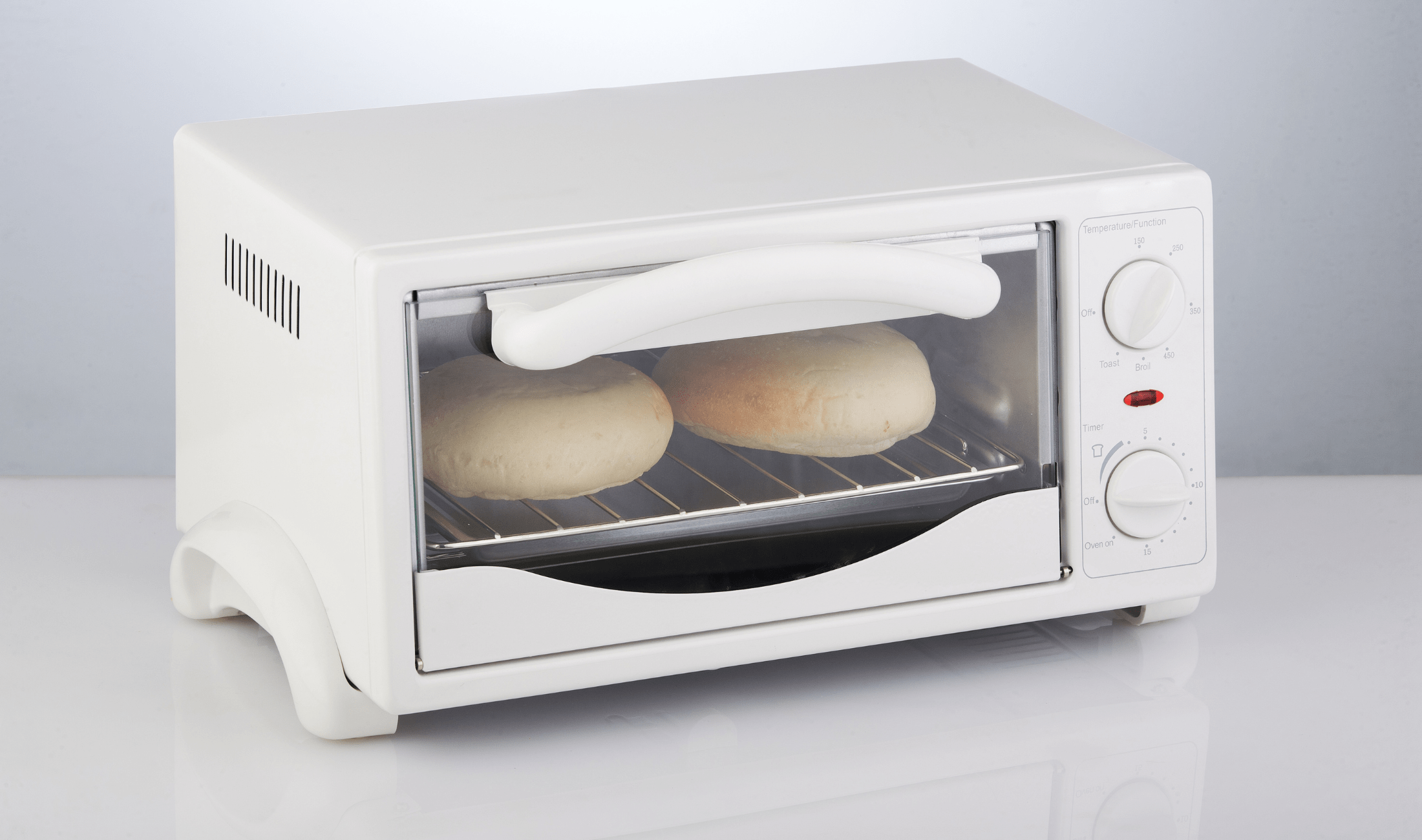 A toaster oven toasting some buns.