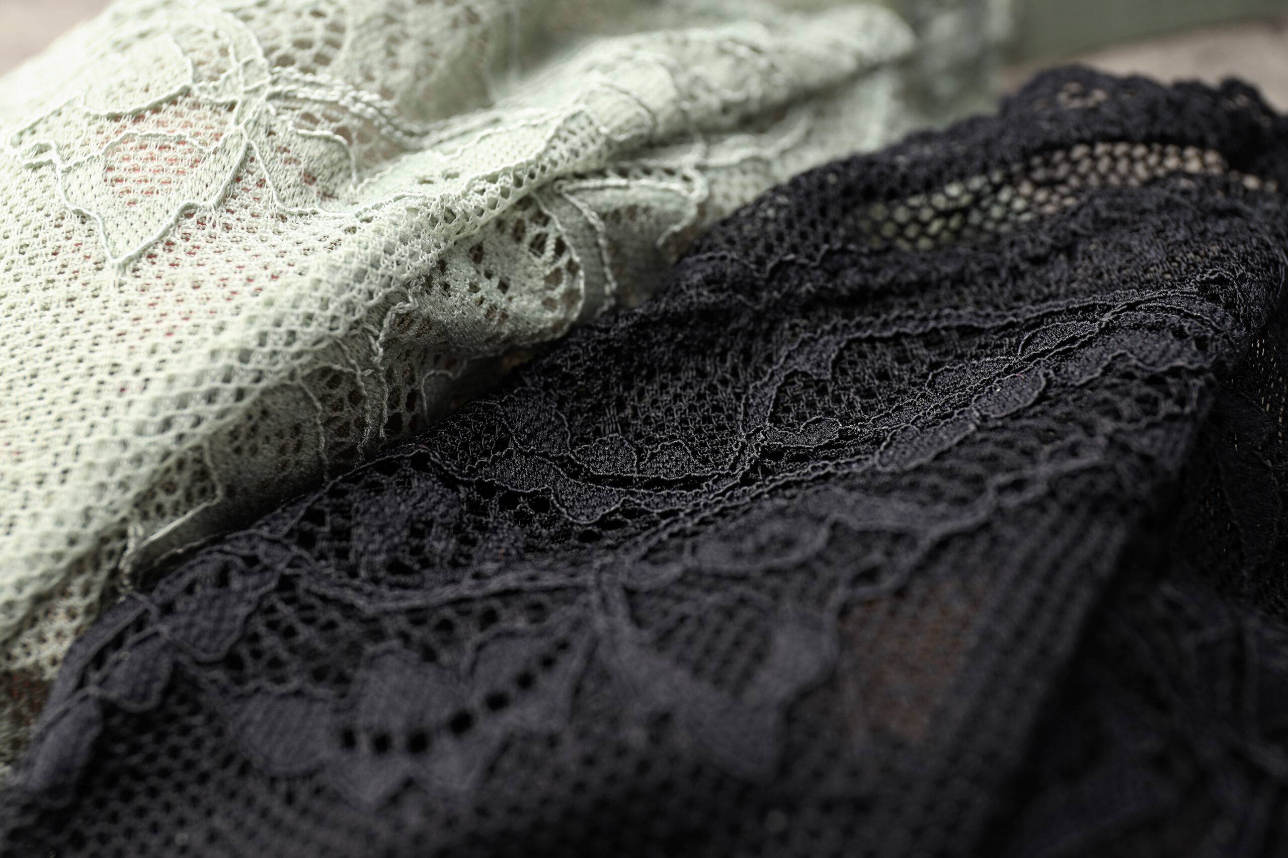 A closeup of two lace fabrics, one white and one black.
