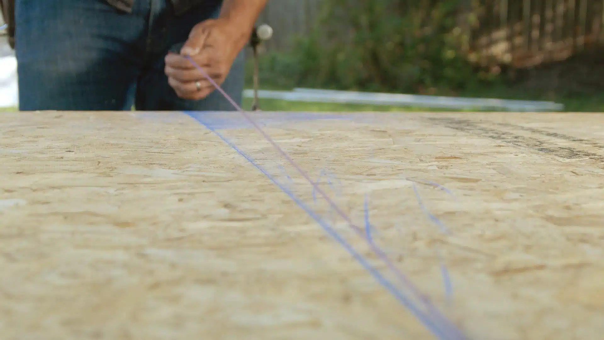 A person making a chalk line with a string.