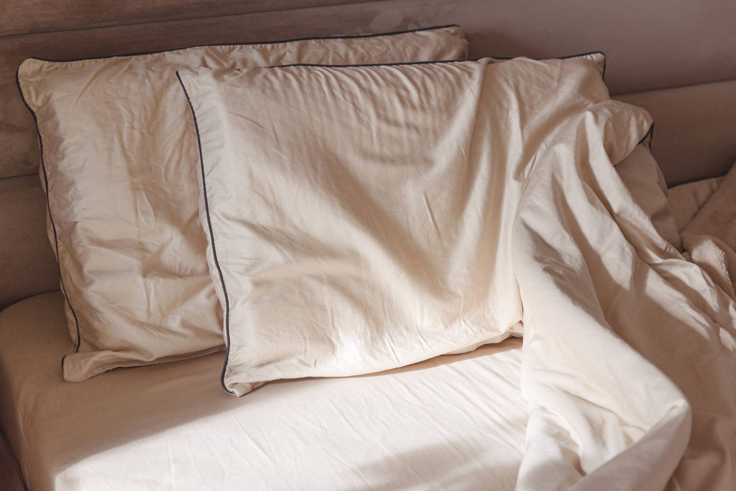 Soft pillows and crumpled sheets on a cozy bed.