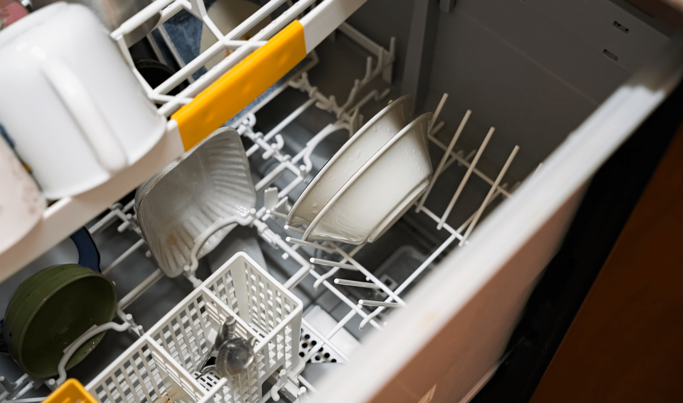 An above view of a dishwasher rack with a few things in it.
