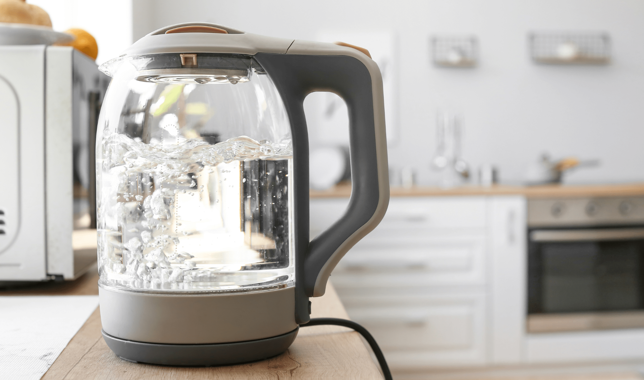 A boiling electric kettle on a kitchen counter.