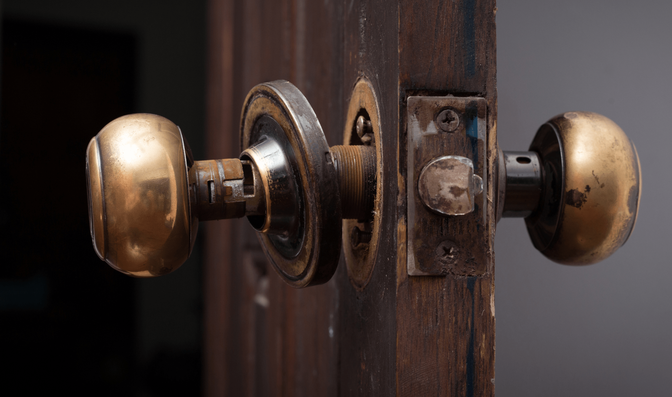 A doorknob slightly pulled out of a door, showing the internal mechanisms.