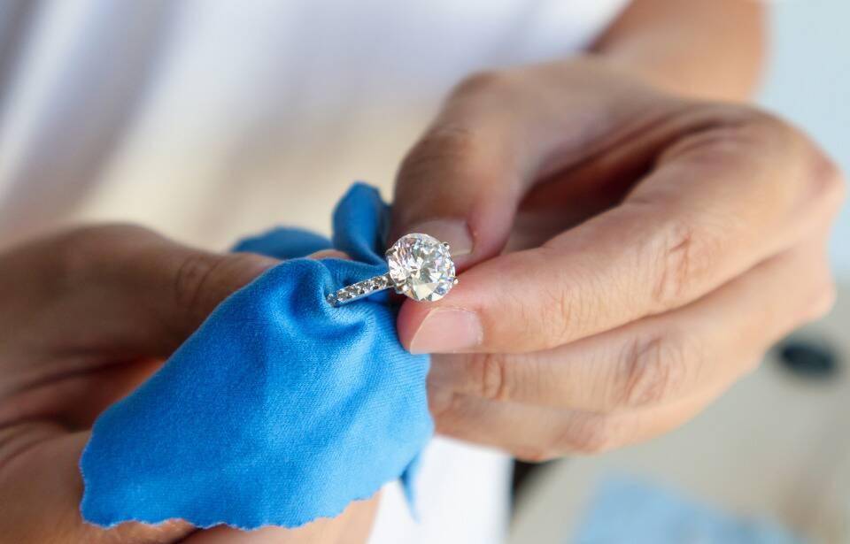 A person polishing a ring with a cloth.