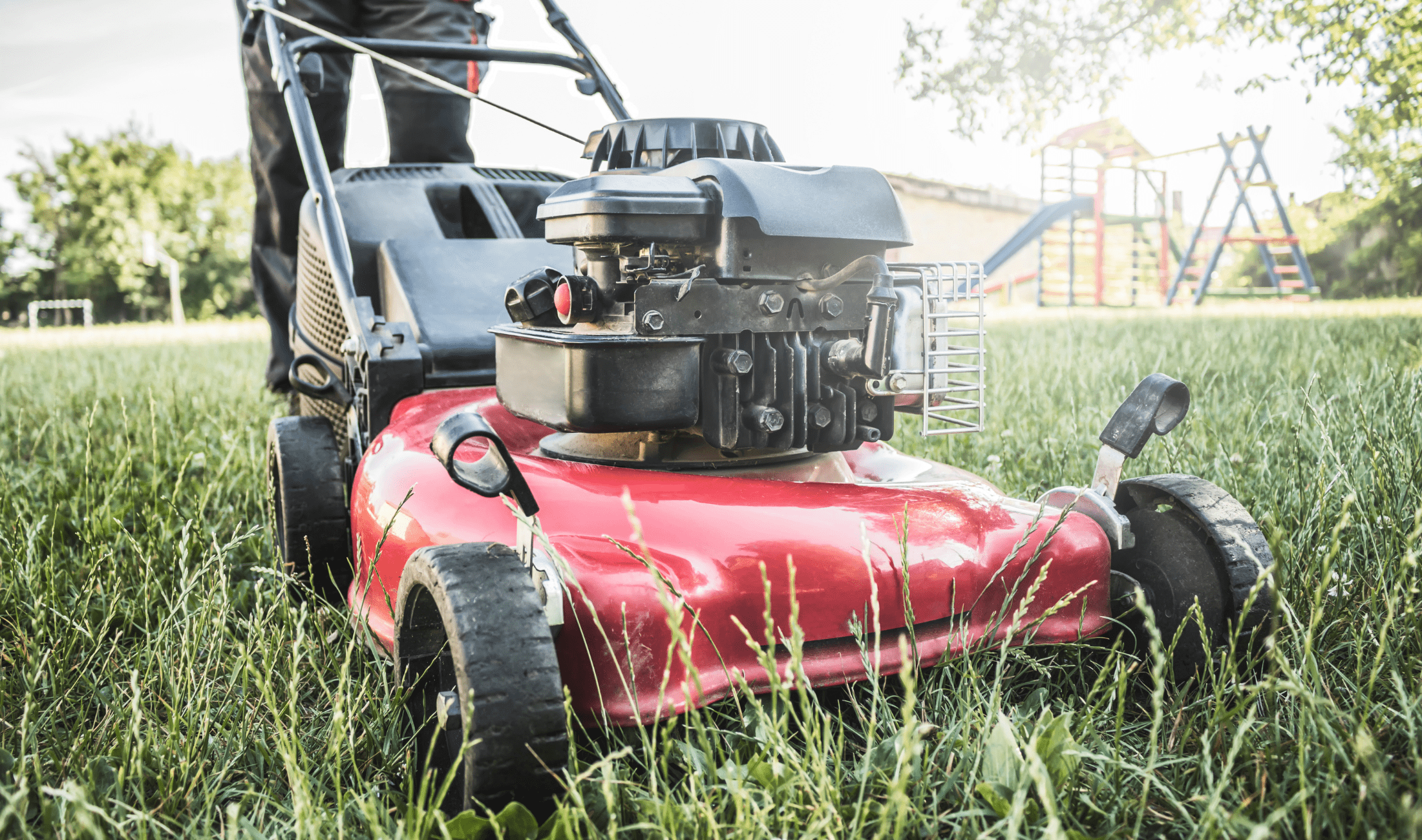 A close, low shot of a lawnmower pushing through grass.