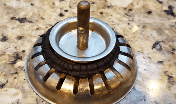 A closeup of a somewhat dirty sink drain stopper.