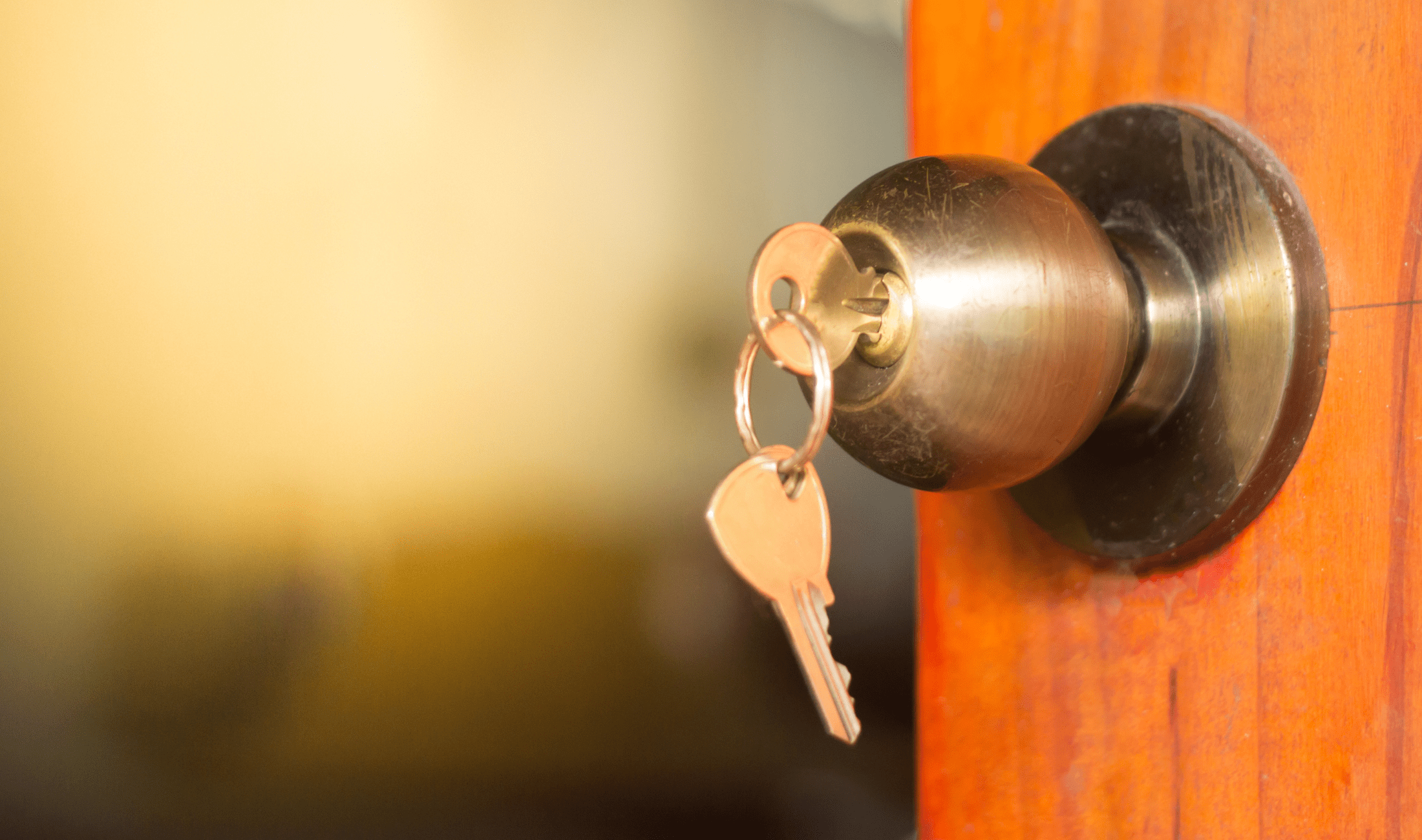 A closeup of a doorknob with a key in the lock.