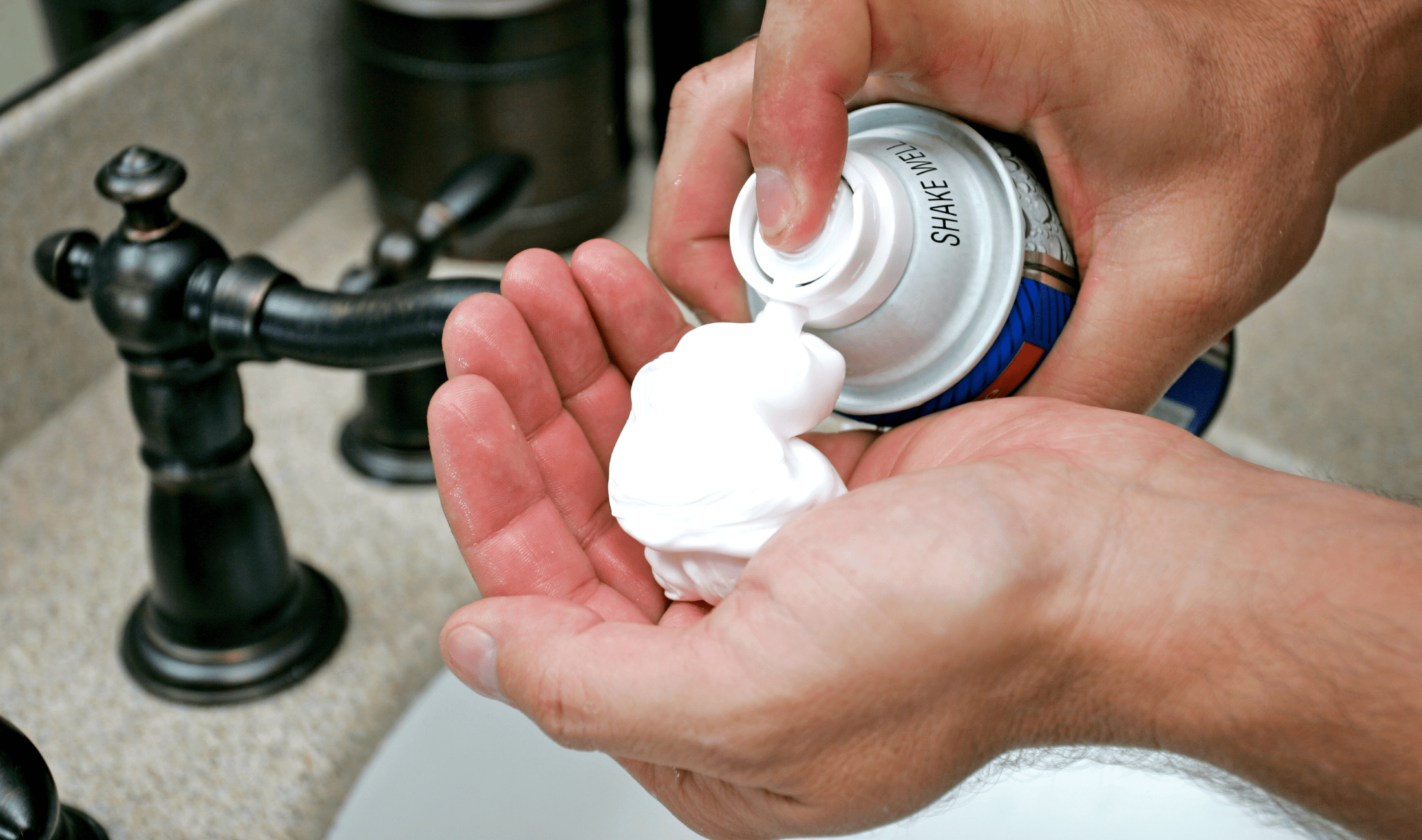 A person filling their hand with shaving cream.