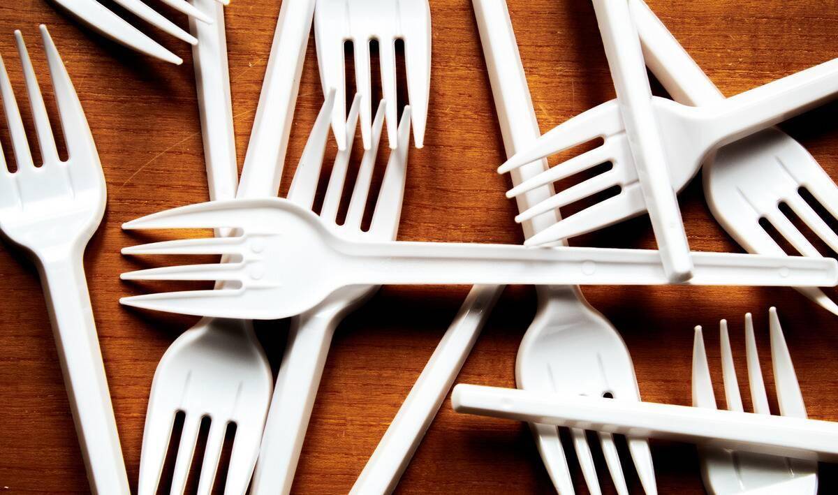 Plastic forks scattered on a wooden table.