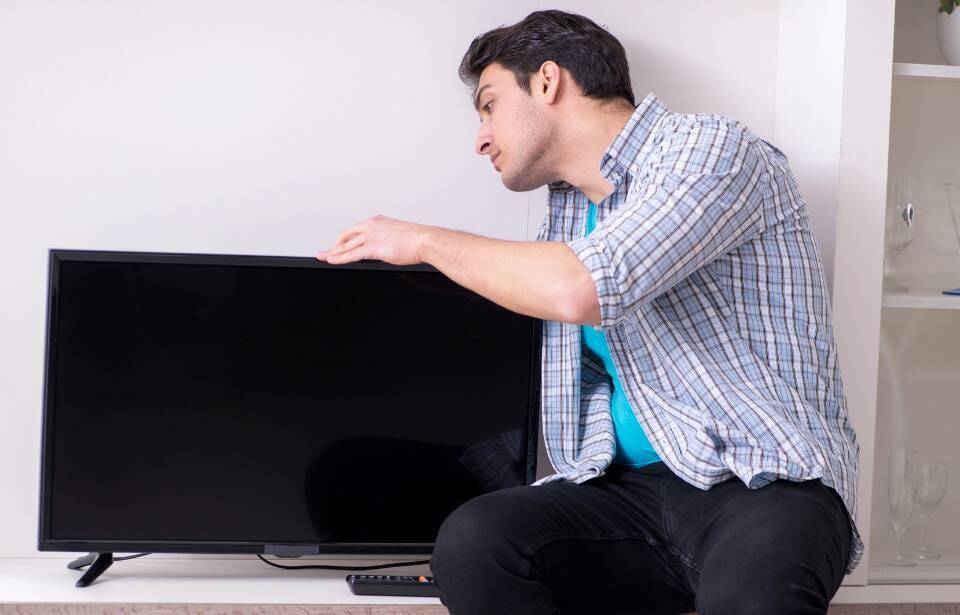 A man holding a small TV.