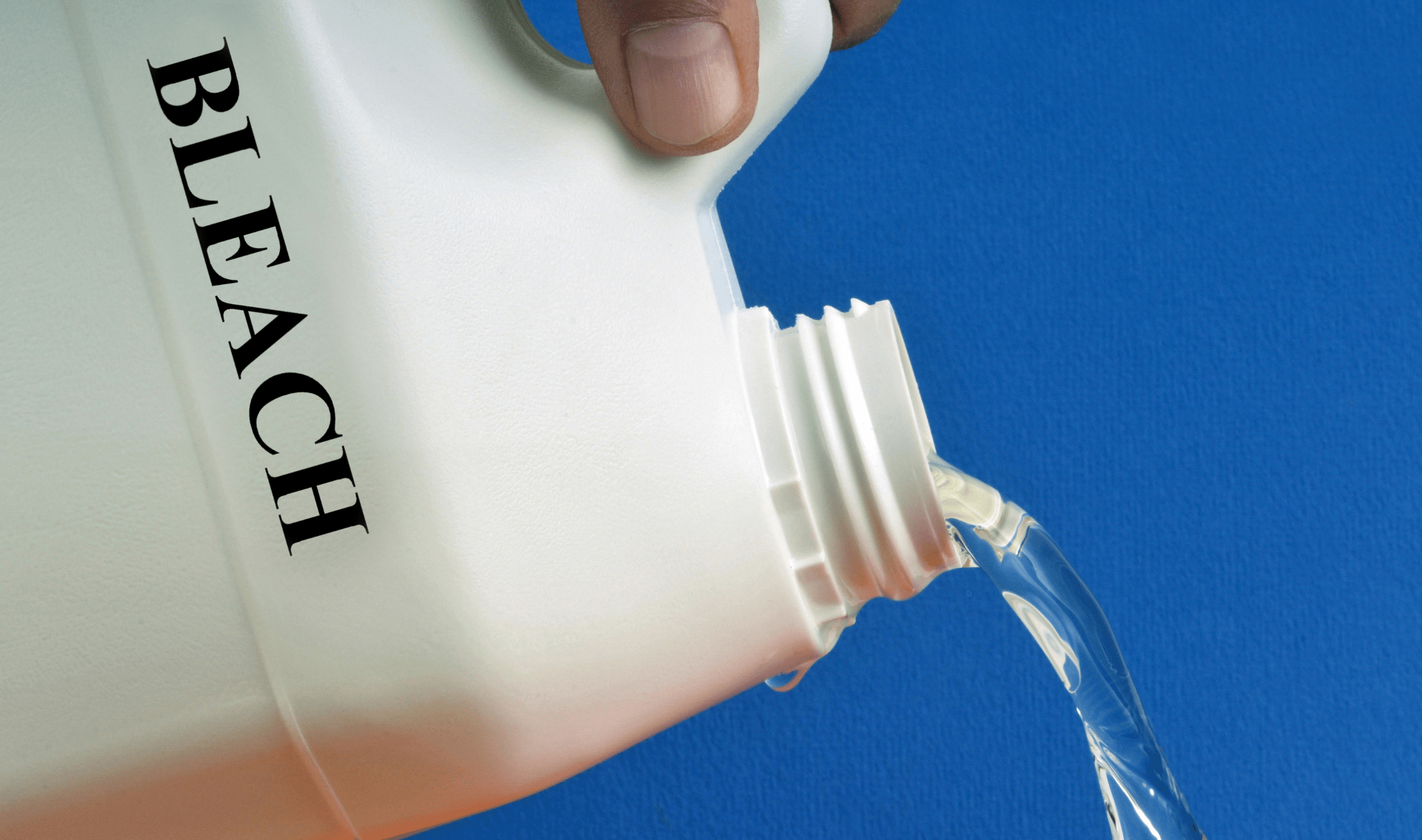 A closeup of someone pouring a bottle labeled 'BLEACH' out of frame.