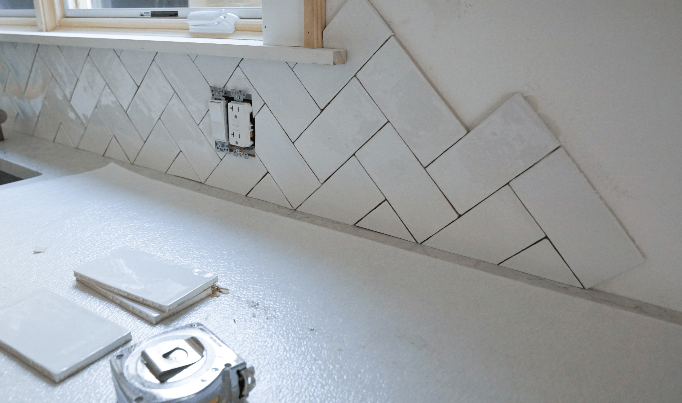 Kitchen tile backsplash being installed.