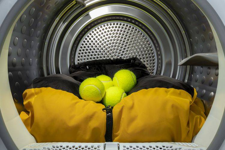Four tennis balls in a dryer drum with some laundry/blankets