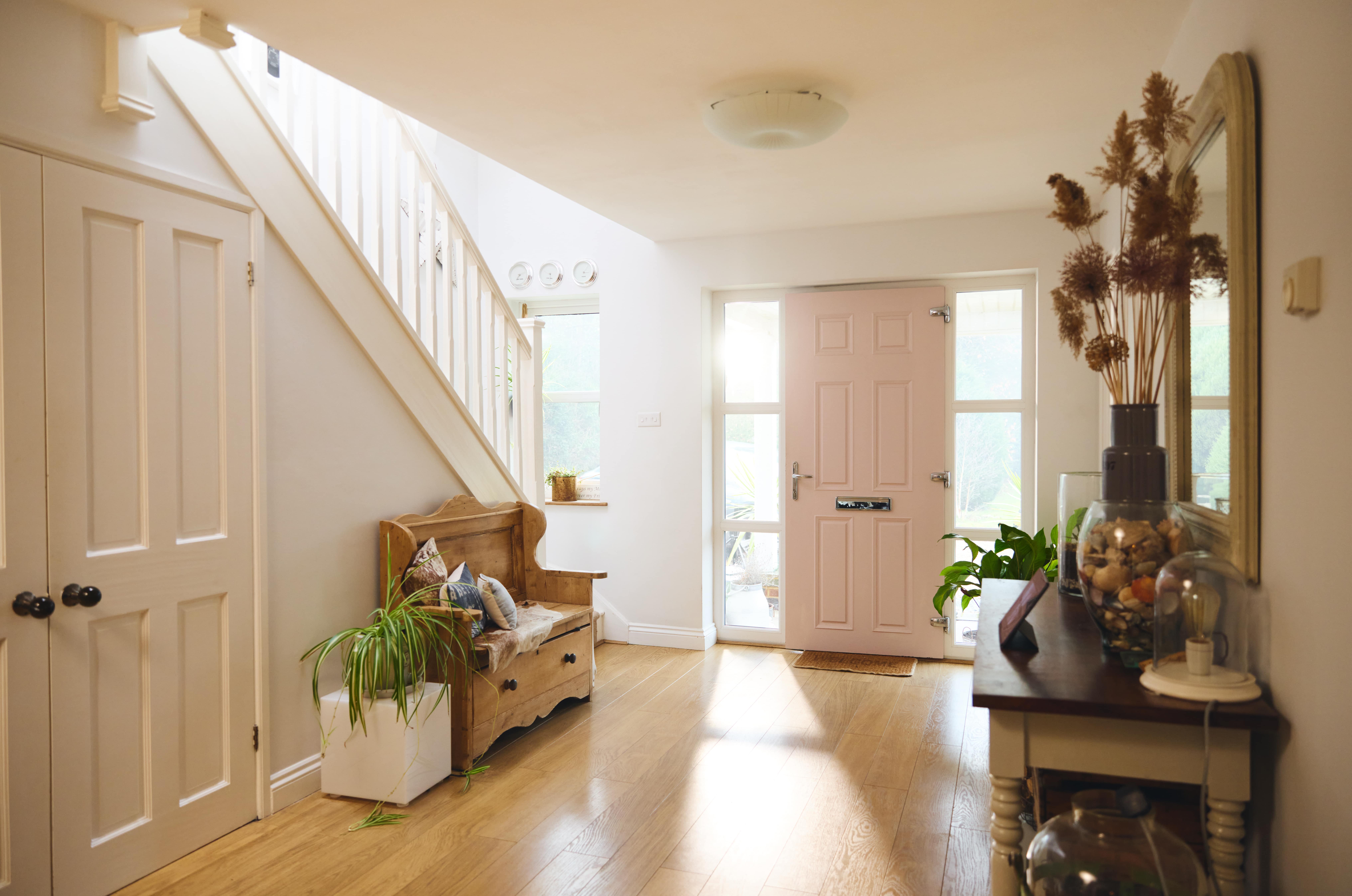 A bright home entryway, largely painted off white.