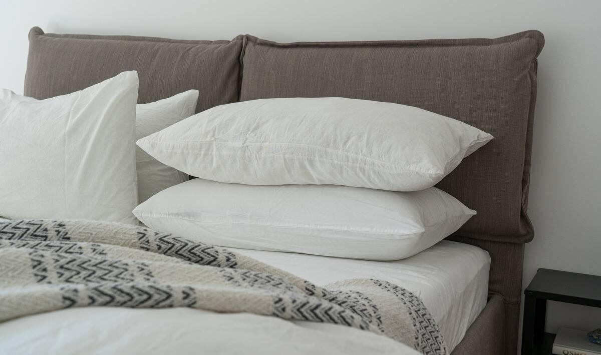 Two clean pillows stacked on a bed.